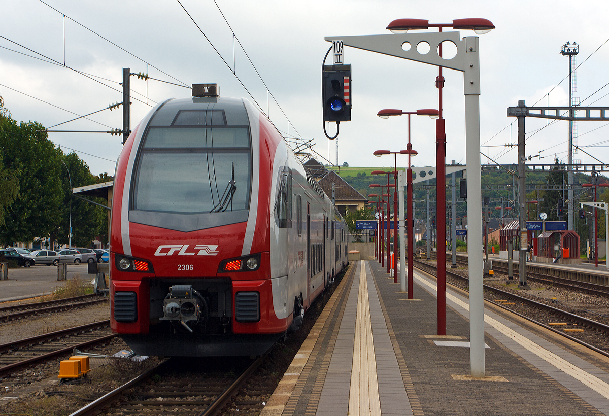 Der CFL 2306 ein dreiteiliger Elektrischer Doppelstocktriebzug Stadler KISS, steht am 14.09.2014 auf Gleis 9 im Bahnhof Wasserbillig als RB nach Luxemburg bereit. Der KISS setz sich zusammen aus den Wagen 94 82 0023 061-3 L-CFL, 94 82 0023 062-1 L-CFL und L-CFL 94 82 0023 063-9 L-CFL.

Diese ersten 8 KISS der 1.Serie (2301 – 2308) wurden 2013 von der Stadler Pankow GmbH (Berlin) gebaut. Weitere 13 weitere Stadler KISS der 2.Serie (2309 – 2321) wurden 2017 (11 St�ck) und 2020 (2 St�ck) gebaut, sie besitzen mehr Sitzpl�tze in der 1. Klasse.

Nach Ank�ndigung der DB Fernverkehr AG, drei der f�nf bestehenden IC-Verbindungen zwischen Luxemburg und Koblenz zu streichen, haben das Ministerium f�r nachhaltige Entwicklung und Infrastruktur Luxemburg, das Ministerium des Innern, f�r Sport und Infrastruktur des Landes Rheinland Pfalz, die CFL, SPNV-Nord und die DB Regio AG eine Ersatzl�sung ausgearbeitet.

Ab dem Fahrplanwechsel Mitte Dezember 2014 ist wie folgt vorgesehen: Eine st�ndliche Zugverbindung zwischen Luxemburg und Koblenz, mit Fl�gelung der von Saarbr�cken kommenden Z�ge (dann FIRT 3) in Trier. Die Verbindung Luxemburgs mit dem deutschen Fernverkehrsnetz wird somit deutlich verbessert.

Die CFL (Soci�t� Nationale Chemins de Fer Luxembourgeois) hat acht dieser dreiteiligen doppelst�ckigen Triebwagen bei Stadler gekauft (mit einer Option auf 31 weitere), diese wurden bei Stadler Pankow GmbH gebaut. Die Fahrzeuge sind mit ETCS ausgestattet und erreichen eine H�chstgeschwindigkeit von 160 km/h. Sie k�nnen unter den Stromsystemen 25 kV, 50 Hz (in Luxemburg) und 15 kV, 16,7 Hz (in Deutschland) verkehren.

Die KISS, die von der Stadler Pankow GmbH gefertigt werden, unterscheiden sich vom urspr�nglichen KISS-Modell dadurch, dass sie das Lichtraumprofil G2 einhalten, um auf dem Netz der DB Netz uneingeschr�nkt eingesetzt werden zu k�nnen. Dadurch ist der Raum im Schulterbereich des Oberstocks enger als bei den Schweizer Triebz�gen. Im Gegenzug dazu war es m�glich, die Einzelwagen zu verl�ngern und den Wagenkasten um 35 mm zu erh�hen. Auch wurden die Fahrzeugk�pfe neu gestaltet, um neueren Crash-Anforderungen zu gen�gen. Dar�ber hinaus sitzen die Stromabnehmer auf den Mittelwagen; in den Endwagen werden nur die Drehgestelle an den Wagen�berg�ngen angetrieben, wobei leistungsst�rkere Motoren eingesetzt werden.

TECHNISCHE DATEN:
Spurweite: 1.435 mm
Achsanordnung: 2‘Bo‘ + 2‘2‘ + Bo‘2‘
L�nge �ber Kupplung: 79.840 mm
Fahrzeugbreite: 2.800 mm
Fahrzeugh�he: 4.630 mm
Lichtraumprofil: G2
Drehzapfenabstand: 18.550 mm
Achsabstand im Drehgestell: 2.500 mm
Triebraddurchmesser: 920 mm (neu)
Dienstgewicht: 170,1 t
Max. Leistung am Rad: 3.000 kW (4�750 kW)
Dauerleistung am Rad: 2.000 kW (4� 500 kW)
Anfahrzugkraft: 200 kN
H�chstgeschwindigkeit :160 km/h
Max. Beschleunigung: 0,83 m/s2 bis 80 km/h
Speisespannung: 25 kV, 50 Hz und 15 kV, 16 ⅔ Hz
Sitzpl�tze (Serie I): 1. Klasse 29 / 2. Klasse 262 (davon 33 Klappsitze)
Sitzpl�tze (Serie II): 1. Klasse 38 / 2. Klasse 254 (davon 33 Klappsitze)
Kupplung: Scharfenbergkupplung (Schaku) Typ 10
Besonderheiten: Mehrfachtraktionsf�hig (bis zu 3 KISS) und mit FLIRT�
