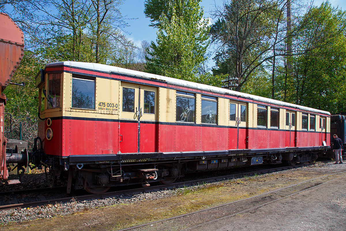 
Der ehemalige Berliner S-Bahn Triebwagen 475 003-0, ex DR 275 031-3, am 30.04.2017 im Eisenbahnmuseum Bochum-Dahlhausen.

Der Triebwagen wurde 1928 von Orenstein & Koppel (O & K) in Berlin gebaut und als elT 2228 an die Deutsche Reichsbahn-Gesellschaft (DRG) geliefert.
Der Wagen hat die folgenden Fahrzeugnummern getragen:
1928 bis 1930 DRG elT 2228
1930 bis 1941 DRG (ab 1937 DR) elT 3150
1941  bis 1970 DR ET 165 080 
1970 bis 1991 DR 275 031-3 
1992 bis 1993 DR 475 003-0 und 
1994 bis zur Ausmusterung 1997 DB 475 003-0.

Der ET 165, später Baureihe 275 (DR) bzw. 475 (DB AG), ist ein elektrischer Triebwagen, der für den Verkehr im Gleichstrom-Netz der Berliner S-Bahn von 1928 bis 1932 gebaut wurde. Die Züge waren noch bis 1997 im Berliner S-Bahn-Netz unterwegs, wurden aber bis Mai 2004 mit Ausnahme einiger Museumsstücke verschrottet.

Die Baureihe ET 165 wurde ab 1928 bis 1932 gebaut. Es handelt sich hierbei um knapp 36 Meter lange sogenannte Viertelzüge, die aus je einem elektrischen Triebwagen und einem antriebslosen Steuerwagen bestanden. Sie ist der hier gezeigte Triebwagen eigentlich nur ein Achtelzug.
Bis zu vier dieser Viertelzüge konnten zu einem rund 145 Meter langen Vollzug gekuppelt eingesetzt werden, der eine in der Praxis nutzbare Platzkapazität von ungefähr 1000 Sitz- und Stehplätzen und ein für damalige Verhältnisse hervorragendes Beschleunigungs- und Bremsvermögen aufwies. Mit dieser Fahrzeugkonzeption konnten die damaligen Anforderungen des Berliner S-Bahn-Verkehrs voll erfüllt werden.

Die Konstruktion basiert auf der DR-Baureihe ET 168 (Bauart Oranienburg) aus dem Jahr 1925. Oberstes Ziel war hierbei die Herabsetzung des Leergewichtes, da die Oranienburger mit etwa 45 Tonnen für den Trieb- und 36 Tonnen für den Steuerwagen für den Stadtbahnbetrieb mit häufigem Halten und Wiederanfahren viel zu schwer ausgefallen war. Man konnte die diese neuen Fahrzeuge durch den Einsatz wesentlich dünnerer, aber aus hochfestem Silizium-Stahl hergestellter Profile um ca. 18 % leichter ausführen (etwa 38 Tonnen beim ET und 27 Tonnen beim ES), außerdem ließen sich zum ersten Mal die Türen vom Führerstand aus schließen. Mit diesen Wagen begann der großflächige Ausbau des elektrifizierten Stadtbahnnetzes in Berlin. Die Fahrzeuge wurden nach einheitlichen Plänen von vielen namhaften Waggonbaufirmen gebaut und in dem eigens für die neuen S-Bahn-Triebwagen damals neu erbauten Reichsbahnausbesserungswerk Schöneweide elektrisch ausgerüstet. Am 11. Juni 1928 fuhr zum ersten Mal diese Baureihe auf der neu elektrifizierten Strecke von Potsdam über die Stadtbahn nach Erkner. Dementsprechend auch als Bauart Stadtbahn bezeichnet, wurde die Baureihe zu einer Legende. Bis Ende 1933 entstanden insgesamt 1276 Einzelwagen, die meist gebaute Triebwagenserie der deutschen Eisenbahngeschichte.

Im Jahr 1932 erfolgte anlässlich der Elektrifizierung der Wannseebahn die Lieferung des letzten Bauloses mit 51 Viertelzügen. Diese Baureihe ET 165.8 erhielt den Namen Bauart Wannseebahn. Sie entsprach bis auf ein geändertes Schaltwerk (jetzt rein elektrisch angetrieben) und einen Wagenkasten ohne sichtbare Nietreihen (Senknietung in Verbindung mit Punktschweißung dünnerer Verkleidungsbleche) der Stammbaureihe ET 165.

Charakteristisch für den Ursprungszustand dieser Baureihe war die Frontansicht mit einem weißen Spitzensignal (Scheinwerfer) in der Mitte und dem beleuchteten Schilderkasten sowie den zwei roten Oberwagenlaternen als Schlusssignal. Die klassische Frontansicht dieser Baureihe blieb bei den meisten Zügen bis Ende der 1960er Jahre erhalten. Die Nachfolgebaureihen ab 1934 (ET 125, ET 166 und ET 167) hatten bereits zwei große Frontscheinwerfer, die entweder ein Zwei-Licht-Spitzensignal oder ein Zwei-Licht-Schlusssignal zeigen konnten.

Von 1965 bis 1969 (und in einer zweiten Serie 1979) wurde ein großer Teil der Stadtbahnwagen auf Einmannbetrieb (EMB) umgebaut. Die Führerstände erhielten Bordfunkgeräte, mit denen der Abfahrauftrag der Aufsichten von den Bahnsteigen übermittelt werden konnte. Der bislang noch notwendige Schaffner, der während der Abfahrt an der Tür stand und den Zug und die Bahnsteigaufsicht zu beobachten hatte, konnte entfallen. Beim Umbau wurden die vorher sehr beengten Führerstände vergrößert. Hierbei mussten im Fahrgastraum vier Sitzplätze an der Führerstandsrückwand entfallen, um diese nach hinten versetzen zu können. Äußerlich waren die Einmannzüge (EMB-Viertel) an den je zwei Spitzen- und Schlusslampen mit Alurahmen der Standardbauart (z. B. E 11 und E 42) in den Stirnwänden und der Antenne für die Abfertigung per Funk zu erkennen.

TECHNISCHE DATEN:

Gebaute Stückzahlen:  638 Triebwagen, 465 Steuerwagen und 173 Beiwagen
Hersteller:  AEG, DWF, O&K, SSW, WUMAG
Baujahre:  1928–1931
Ausmusterung:  1997
Spurweite:  1.435 mm (Normalspur)
Achsformel:  Bo'Bo'
Breite:  3.000 mm
Drehzapfenabstand:  11.800 mm
Drehgestellachsstand: 2.500 mm
Leergewicht:  38,4 t
Höchstgeschwindigkeit:  80 km/h
Stundenleistung:  360 kW
Beschleunigung:  0,3 und 0,5 m/s² je nach Fahrschalterstellung
Raddurchmesser:  900 mm
Stromsystem:  750 V =
Stromübertragung:  seitliche, von unten bestrichene Stromschiene
Anzahl der Fahrmotoren:  4
Zugheizung:  elektrisch
Geschwindigkeitsmesser:  DEUTA
Kupplungstyp:  Scharfenbergkupplung
Fußbodenhöhe:  1.100 mm