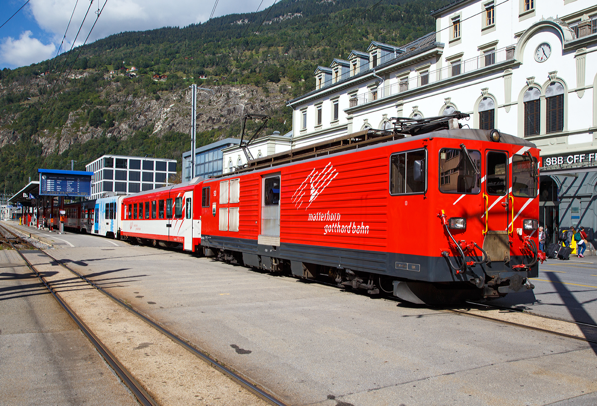 
Der Elektrischer Zahnradtriebwagen Deh 4 /4 - 93 „Oberwald“ f�hrt am 16.09.2017, mit einem Regionalzug, vom Bahnhof Brig weiter in Richtung Andermatt. 

Der Gep�cktriebwagen wurde 1979 von SLM (mechanischer Teil, Lokomotivkasten) und BBC (elektrische Ausr�stung) gebaut.

Die vier 1979 bei der Furka- Oberalp-Bahn in Betrieb genommenen Gep�cktriebwagen sind f�r Adh�sions- und Zahnstangenstrecken konzipiert. Zwei weitere Einheiten wurden 1982 in Auftrag gegeben. Sie werden auf dem ganzen Streckennetz – maximale Steigung 179%o - als Triebfahrzeuge f�r Z�ge mit vier bis f�nf Wagen eingesetzt.
Der biege- und verwindungssteife, extrem leichte Kasten wurde in Stahl ausgef�hrt und die hohe Steifigkeit durch Strukturgebung erzielt. Dem leichten Innenausbau und der ergonomischen F�hrerstandgestaltung wurde ebenfalls besondere Aufmerksamkeit geschenkt.
Die Drehgestelle, die durch tiefliegende Drehzapfen �ber Traversen  it dem Kasten verbunden sind, enthalten je zwei Antriebsmotoren. Die Betriebsverh�ltnisse erfordern drei unabh�ngige Bremssysteme.

Die ehemaligen Deh 4/4 I und II der FO (Furka-Oberalp-Bahn) werden im Einsatz nicht unterschieden, wenn n�tig, dann anhand der Seriennummern 2.., 5.. und 9... Wobei sie sich optisch und technisch schon etwas unterscheiden. Sie werden haupts�chlich zusammen mit zwei Mittelwagen und einem Steuerwagen als fest gekuppelte Pendelz�ge eingesetzt. Zwischen Disentis und Andermatt (Oberalp, 110‰) kann ein und zwischen Visp und Andermatt (Goms, 90‰) k�nnen zwei, im Sommer drei Verst�rkungswagen angeh�ngt werden. Zwischen Andermatt und G�schenen (Sch�llenenschlucht, 179‰) sind keine Verst�rkungswagen m�glich. Die Pendelz�ge sind innerhalb der Komposition mit der automatischen +GF+-Kupplung (GFN) verbunden. F�r andere Verwendungen m�ssen die Kupplungen getauscht werden. Mindestens ein Triebwagen, fr�her waren dies meist Nr. 95 oder 96, dient als Ersatzfahrzeug f�r die �brigen Deh und wird auch allein f�r �berfuhren eingesetzt. Fr�her wurden auch G�terz�ge nach G�schenen gef�hrt.

Technische Daten:
Spurweite: 1.000 mm
Achsformel: Bo’Bo’
L�nge �ber Puffer: 15.500 mm
Drehzapfenabstand: 8.800 mm
Achsabstand im Drehgestell: 2.790 mm
Gr��te Breite: 2.683 mm
Gr��te H�he (bei abgesenkten Stromabnehmer): 3.880 mm
Leergewicht: 49,5 t (davon Mechanischer Teil 28 ,5 t)
Dienstgewicht: 51,0 t
Maximale Zuladung: 1,5 t
H�chstgeschwindigkeit: Adh�sion 60 km/h / Zahnstange 30 km/h
Stundenleistung: 1.032 kW
Dauerleistung: 936 kW
Stundenzugkraft am Rad: 117,2 kN
Dauerzugkraft am Rad: 101,2 kN
Maximale Zugkraft am Rad: 247,2 kN
Stromsystem: 11 kV 16,7 Hz AC
Anzahl der Fahrmotoren: 4
