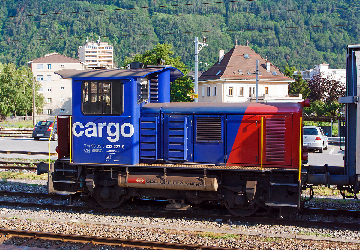 
Der Rangiertraktor (Rangierlok) Tm 232 227-9 (Tm 98 85 5 232 227-9 CH-SBBC) der SBB Cargo, ex SBB Tm IV -  9677, ist am 28.05.2012 beim Bahnhof Martigny abgestellt.

Die Lok wurde 1976 von der SLM unter der Fabriknummer 5084 gebaut und an die SBB, als Tm IV -  9677, geliefert. Ein Umbau, Remotorisierung (einschl. Partikelfiltern der neuesten Generation ohne Brenner) und Einbau einer Funkfernsteuerung erfolgte ca. im Jahr 2010 im SBB Industriewerk Biel, danach erfolgte die Umzeichnung in Tm 232 227-9. 

Als Tm IV werden bei der Schweizerischen Bundesbahnen (SBB) die 80 Rangiertraktoren mit Dieselantrieb bezeichnet, die zwischen 1970 und 1978 beschafft (und von der SLM gebaut) wurden. Der Index IV steht für die Leistungsklasse IV (über 350 PS).

Die Fahrzeuge wurden als fahrdrahtunabhängiges Fahrzeug für den Rangier- und Baudienst beschafft. Erstmals bei einer großen SBB-Fahrzeugserie, kam bei diesen Fahrzeugen die hydraulische Kraftübertragung zum Einsatz. Da das Turbowendegetriebe eine Ausrüstung für beide Fahrtrichtungen hatte, konnte auf das störungsanfällige mechanische Wendegetriebe verzichtet werden. Um die ungünstige Wirkungsgradcharakteristik abzuschwächen, wurde ein nur im Stillstand schaltbares Stufengetriebe eingebaut, das die Wahl zwischen einer Höchstgeschwindigkeit von 30 oder 60 km/h, oder die Wahl zwischen größerer Zugkraft oder größerer Geschwindigkeit ermöglicht.

Die Rangiertraktoren besitzen einen Außenrahmen mit obenliegenden Blattfedern, die sich auf die Achslager abstützen. Die Federn besitzen keinen Lastausgleich.

Die Kraftübertragung erfolgt von der Motorwelle über eine Kardanwelle (Gelenkwelle) zu einem zentralen Schaltgetriebe. Dieses ist als Voith-Turbogetriebe mit nachgeschaltetem Verteilgetriebe ausgeführt. Von dessen Antriebswelle (beidseitig)  weiter über zwei Gelenkwellen auf eine Achsgetriebe, das sich auf der jeweiligen Antriebachse befindet. Die beiden Achsen sind über die Gelenkwellen und Antriebswellen mechanisch verbunden.

Das Voith-Turbogetriebe ist ein vollautomatisch arbeitendes hydrodynamisches Strömungsgetriebe, das zwei Wandler besitzt. Als Betriebsflüssigkeit kommt Mineralöl zu Einsatz. Die beiden Wandler sind zueinander gegenläufig, wodurch die Fahrtrichtung geändert wird. Dem Turbogetriebe ist das Verteilgetriebe nachgeschaltet. Dort kann mechanisch die Übersetzung zwischen Rangier- und Streckengang geschaltet werden. Da es sich um ein nicht synchronisiertes Schaltgetriebe handelt, darf es nur im Stillstand geschaltet werden. Es besitzt auch eine Neutralstellung, in welchen der Schalthebel bei Schleppfahrt gebracht und verriegelt wird. Das Achsgetriebe besteht aus einem Kegelradgetriebe mit einem Übersetzungsverhältnis 1:3.357. Auf der der Kardanwelle abgewandten Seite ist das Gehäuse des Achsantriebes mit einer Drehmomentabstützung mit dem Fahrzeugrahmen verbunden.

Als Motor wurde ein schnelllaufender nicht aufgeladener 8-Zylinder Dieselmotor eingebaut. Die ersten Fahrzeuge waren mit einem MAN Motor des Typs R8V 16/18, mit 280 kW / 380 PS Leistung, ausgerüstet, dessen Produktion später von der MTU übernommen wurden. 

Umbau zu Tm 232
Neben der Neumotorisierung war der Einbau einer Zugsicherung der wichtigste Umbaupunkt, denn es werden doch heute vermehrt Streckenfahrten mit den Rangiertraktoren unternommen. Es kommt ein Caterpillar 6 Zylinder-Dieselmotor des Typs 13C Acert mit Ladeluftkühler und Partikelfilter zum Einbau. Die Motorleistung beträgt nun 310 kW, mehr lässt das hydraulische Getriebe auch nicht zu. Daneben wurde die Spannung der Steuerung von 36 Volt auf 24 Volt abgeändert. Neben dem Einbau einer neuen Sicherheitssteuerung und Zugsicherung werden auch alle Fahrzeuge mit einer modernen Funkfernsteuerung ausgerüstet. Die Umbauten wurden im Industriewerk Biel durchgeführt, das heute der SBB Division Personenverkehr zugeteilt ist.


TECHNISCHE DATEN (Tm 232, ex Tm IV)
Spurweite:  1.435 mm (Normalspur)
Achsformel: B
Länge über Puffer:  7.670 mm
Achsabstand:  3.570 mm
Treibraddurchmesser: 	 950 mm
Kleinster bef. Halbmesser: 	35m
Dienstgewicht: 	30 t
Höchstgeschwindigkeit: 30 (Rangiergang) / 60 km/h (Streckengang) / 90 km/h (geschleppt)
Traktionsleistung:  310 kW/421 PS (urspr. 280 kW / 380 PS)
Anfahrzugkraft: 90 kN
Dauerzugkraft:  60 kN
Motor (neu): 6 Zylinder Reihenmotor vom Typ Caterpillar 13C Acert)
Ursprünglicher Motor: 	8 Zylinder Reihenmotor vom Typ MAN Typs R8V 16/18
Leistungsübertragung:  Hydraulisch
Tankinhalt:  850 l (Diesel)
