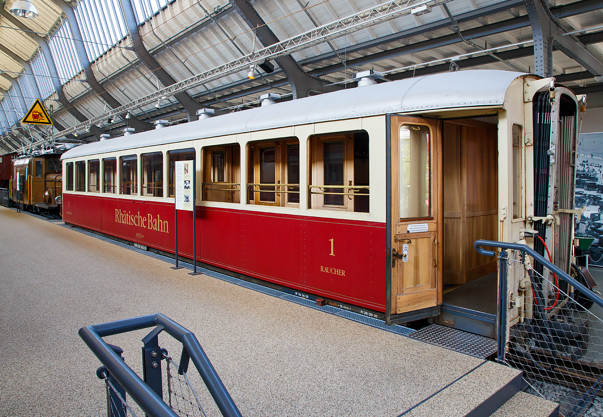 Der RhB 1.Klasse Salonwagen As 1154 (ex Schnellzugwagen A 1154, ex A4� 1154, ex A4� 54), ausgestellt im Verkehrszentrum des Deutschen Museums in M�nchen (Theresienh�he), hier am 16.06.2018.  

Als Wagen der Stahlbauart wurde dieser 4-achsige Wagen 1930 von SIG (Schweizerische Industrie-Gesellschaft, Neuhausen) unter der Fabriknummer 27802a gebaut und an die RhB ausgeliefert. Bei einer L�nge von 16,44 m bietet er neben einer WC-Einrichtung 35 Sitzpl�tze aufgeteilt auf 6 Abteile. Er ist der einzige Wagen der schweren Stahlbauart, der zwei sehr voneinander abweichende Seitenw�nde besitzt. Die Anordnung der Abteilseitenwand ist denen der anderen Wagen �hnlich, die Gangseite besitzt aber 1o Fenster die fast die ganze Seitenwand ausf�llen.

Der 1154 war viele Jahre auf den Strecken der Rh�tischen Bahn unterwegs und wurde dann ebenfalls wie der 1161 eine Zeit lang als Me�wagen eingesetzt, bevor er 1986 zu einem Salonwagen umgebaut wurde. Im Juni 2001 wurde er ausgemustert. Zusammen mit der Ge 6/6 I – 411 zog er nach M�nchen um, wo er als Leihgabe dem Deutschen Museum zur Verf�gung gestellt wurde und seitdem dort ausgestellt ist.

Der Salonwagen 1154 ist heute der einzige historische Seitengangwagen, der bei der Rh�tische Bahn erhalten blieb.

TECHNISCHE DATEN:
Spurweite: 1.000 mm 
Anzahl der Achsen: 4 
L�nge �ber Puffer: 16.440 mm 
H�he: 3.450 mm
Drehzapfenabstand: 11.200 mm
Achsabstand im Drehgestell: 1.700 mm
Laufraddurchmesser: 750 mm
Sitzpl�tze: 35 
Fahrzeuggewicht; 25,0 t 
Ladegewicht: 12,50t zul�ssige 
zul�ssige Geschwindigkeit: 90 km/h