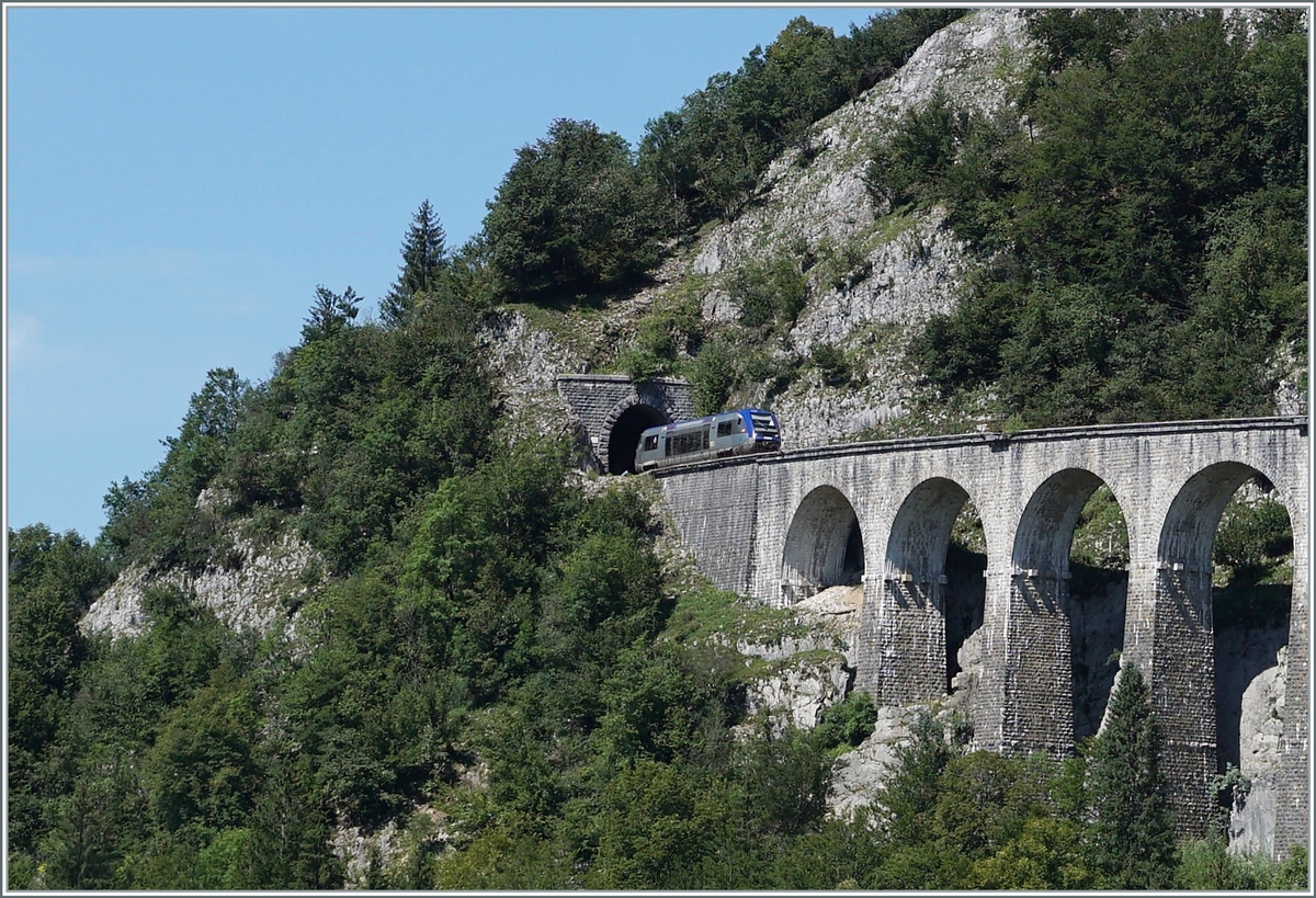 Der SNCF X 73657 hat den 69 Meter langen Tunnel des Crottes verlassen und fährt nun über den aus zehn Bogen und in einer langen Kurve liegenden 165 Meter langen Viaduc des Crottes. Der Dieseltriebwagen ist als TER 895511 von Dole nach St-Claude unterwegs.

10. August 2021