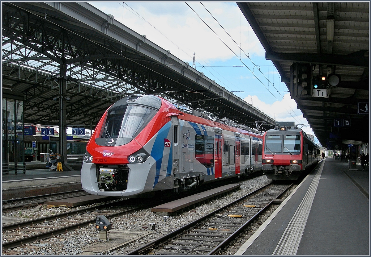 Der SNCF Z 31503 M (UIC 94 87 0031 503-9F-SNCF) in LÉMAN EXPRESS Farbgebung bei Probefarhten mit einem SNCF blau/grauen Schwesterfahrzeug in Lausanne, der zweite Coradia Polyvalent régional tricourant ist jedoch durch den Domino auf Gleis 1 verdeckt. 

29. April 2019