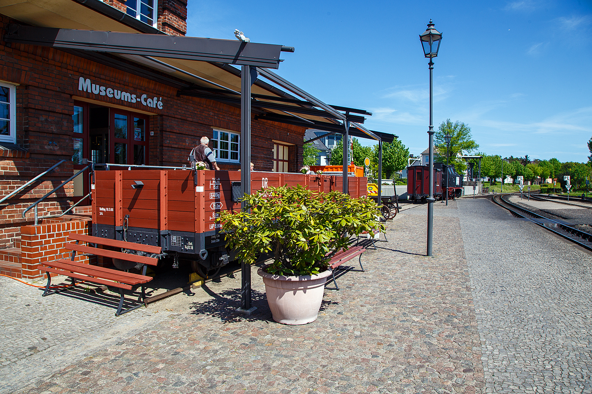 Der Terassenwagen, ein vierachsiger offener Güterwagen ex DR 98-02-55 der Gattung OOw, am Molli-Museums-Café beim Bahnhof Ostseebad Kühlungsborn-West (bis 1938 Ostseebad Arendsee) der Mecklenburgischen Bäderbahn Molli am 15.05.2022.

Der Wagen wurde 1911 von der Waggonfabrik Wismar für die DHE - Doberan-Heiligendammer-Eisenbahn (ab 1. April 1920 zur Deutschen Reichsbahn), gebaut. Von 2005 bis 2006 wurde er rekonstruiert und dient seit 2006 als Terassenwagen des Molli-Cafes.

TECHNISCHE DATEN:
Spurweite: 900 mm
Gattung: OOw
Anzahl der Achsen: 4
Länge über Puffer: 8.800 mm
Drehzapfenabstand: 5.000 mm
Achsabstand im Drehgestell: 1.300 mm
Länge der Ladefläche: 8.000 mm
Ladefläche: 16 m²
Eigengewicht: 6.400 kg
Tragfähigkeit: 14,3 t
