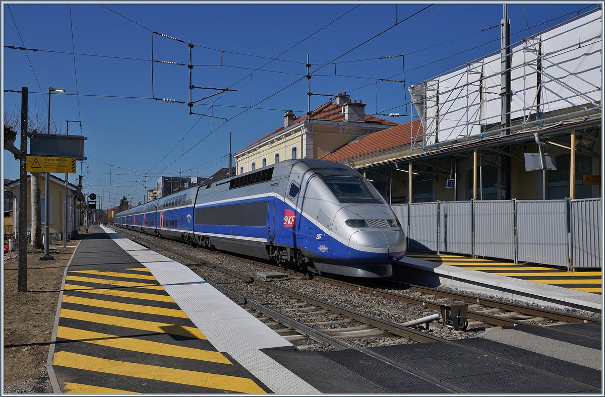 Der TGV  Paris-Alpes  6501, geführt vom SNCF Triebzug 287, ist von Thonon zum Halten gekommen. Weitab der Hochgeschwindigkeitsstrecke zeigt sich der Zug von einer etwas anderen Art; der Halt dauert ein paar Minuten und ich kann sogar noch vor dem Zug über die Gleise, dass nicht rot leuchtende Licht unten recht im Bild erlaubt dies, und mit dem TGV nach Evian fahren.

23. März 2019