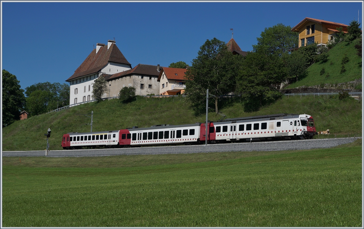 Der TPF RABe 567 182 ist bei Vaulruz auf dem Weg nach Bulle vor dem Hintergrund schmucker Geb�ude des Ortes. 

19. Mai 2020