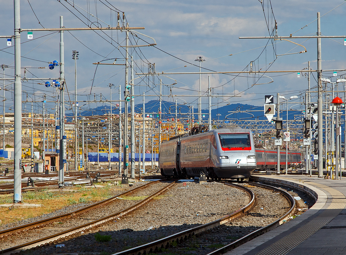Der Trenitalia Frecciargento ETR 485 – 42 (Pendolino), ex ETR 480 – 42, erreicht am 13.07.2022 den Zielbahnhof Roma Termini. Frecciargento hei�t deutsch Silberpfeil.

Die ETR 480 (von italienisch ElettroTreno Rapido) oder umgangssprachlich Pendolino sind von Trenitalia betriebene italienische Neigez�ge von Fiat Ferroviaria, die zweisystemf�higen Einheiten tragen die Reihenbezeichnung ETR 485.

Die ETR 485 (ex ETR 480) geh�ren zur dritten Generation von Pendolino-Z�gen. Sie basieren auf der Baureihe ETR 460, von der sie sich �u�erlich kaum unterscheiden lassen. Sie gingen als Einsystemz�ge f�r 3 kV Gleichspannung in Betrieb, waren aber von Beginn an f�r den Einbau der zus�tzlichen Ausr�stung f�r 25 kV Wechselspannung vorbereitet. Notwendig wurde der Einbau dieser Ausr�stung f�r das Befahren der Schnellfahrstrecken Rom–Neapel und Turin–Mailand. Die Z�ge wurden 2004 bis 2005 f�r den Zweisystembetrieb umgebaut und der neuen Baureihe ETR 485 zugeordnet. Die Z�ge werden vor allem auf der Strecke Rom–Mailand–Turin eingesetzt und verkehren unter der Bezeichnung Frecciargento.

Die Z�ge bestehen aus neun einzeln lauff�higen Wagen und technisch aus drei unabh�ngigen Traktionseinheiten. Jeder der Drittelz�ge besteht aus einem antriebslosen Wagen und zwei Wagen mit je einem Stromrichter in GTO-Thyristor-Technik und zwei Fahrmotoren. Die unter dem Wagenkasten in L�ngsrichtung aufgeh�ngten Fahrmotoren treiben jeweils die innere Achse des benachbarten Drehgestells an, sodass jeder Antriebswagen �ber zwei Treibachsen verf�gt.

Die Z�ge haben wie die Vorg�nger ETR 460 Endwagen mit einer breiten, eher eckiger wirkenden Kopfform, die vom Industriedesigner Giorgio Giugiaro entworfen worden war. Die Mittelwagen wurden aus leichten, extrudierten Aluminiumprofilen gebaut. Das vollst�ndig unterflur angeordnete Neigetechniksystem wurde gegen�ber den ETR 460 leicht �berarbeitet. Die Z�ge sind mit der Fahrzeugausr�stung der Zugbeeinflussungen BACC und ETCS Level 2 ausger�stet.

TECHNISCHE DATEN:
Anzahl: 15
Hersteller: Fiat Ferroviaria
Baujahre: 1997–1999, Umbau 2004–2005
Spurweite: 1.435 mm (Normalspur)
Achsformel:(1A)(A1) + (1A)(A1) + 2’2’ + 2’2’ + (1A)(A1) + (1A)(A1) + 2’2’ + (1A)(A1) + (1A)(A1)
L�nge: 236.600 mm
Leergewicht: 454 t (als ETR 480: 433 t)
Radsatzfahrmasse: 14,5 t
H�chstgeschwindigkeit: 250 km/h
Dauerleistung: 12 � 490 kW = 5.880 kW
Stromsystem: 25 kV, 50 Hz ~ und 3 kV =
Strom�bertragung: Oberleitung
Sitzpl�tze: 139 (1. Klasse) und 342 (2. Klasse)
