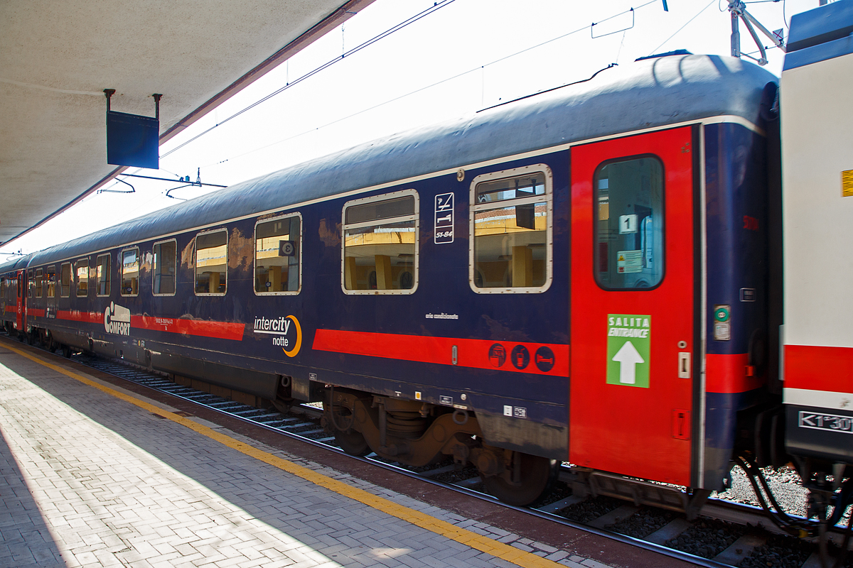 Der Trenitalia intercity notte Comfort Schlafwagen der Gattung Bc, eingereiht als Wagen 1 in den ICN 1959 von Roma Termini nach Syrakus (Siracusa), am 18.07.2022 im Bahnhof Catania Centrale. Diese Wagen haben bis zu 32 Schlafwagenpl�tze (am Tag Sitzpl�tze und in der Nacht Betten). 

TECHNISCHE DATEN: 
Spurweite: 1.435 mm
L�nge �ber Puffer:  26.400 mm
Drehzapfenabstand: 19.000 mm
Sitzpl�tze: 32 (2. Klasse), bzw. bei Nacht Betten
Eigengewicht: 44 t
H�chstgeschwindigkeit:  160 km/h
Bremsbauart:  Freno WU-R 65t