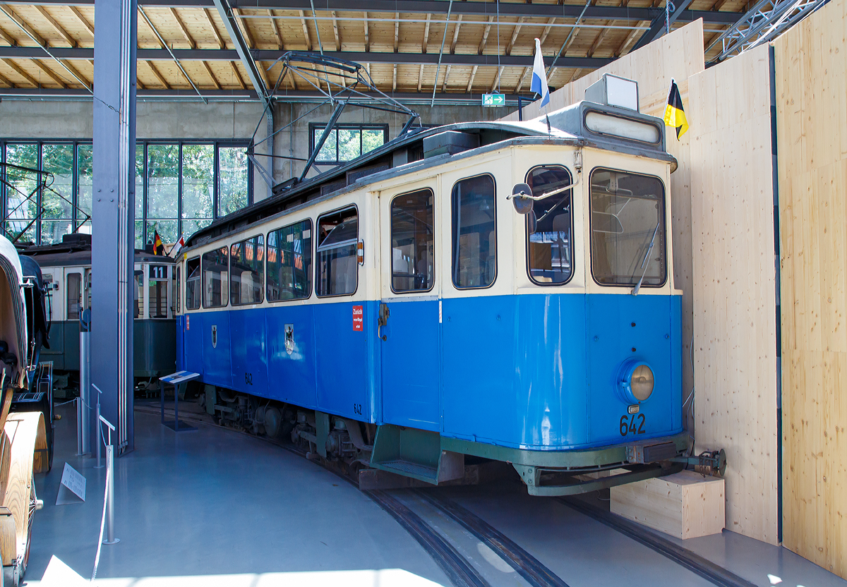
Der Triebwagen 642 vom Typ F 2.10 der Städtischen Straßenbahnen München (heute Münchner Verkehrsgesellschaft - MVG) (am 16.06.2018) ausgestellt im Verkehrszentrum des Deutschen Museums in München (Theresienhöhe).

Der Straßenbahn-Triebwagen 642 vom Typ F wurde 1930 in einer Serie von 40 Wagen von der Firma Hannoverische Waggonbau gebaut.

Der Ausbau des Münchener Trambahnnetzes machte Ende der 1920er Jahre eine erneute Ergänzung des Fuhrparks notwendig. Ähnlich wie die Vorgängerserie, die E-Wagen, zeichneten sich die F-Wagen durch große, geschlossene Plattformen und Maximum-Drehgestelle aus. Im Gegensatz zum Vorläufer – die Typenbezeichnung wurde fortlaufend nach dem Alphabet vorgenommen - waren die F-Wagen bei den Münchenern besonders beliebt, weil sie wieder die klassische weiß-blaue Lackierung trugen.

Die F-Wagen waren die letzten vor dem Krieg gelieferten Münchener Trambahnwagen. Während des Krieges wurden 17 von ihnen zerstört und ein Teil in anderer Form wieder aufgebaut. Die erhalten gebliebenen Wagen wurden 1943 zum Einrichtungsbetrieb umgebaut und erhielten in den 1950er Jahren notwendige Sicherheitseinrichtungen wie zum Beispiel Schienenbremsen. Zeitgleich wurden sie nach der Auslieferung der ersten Großraumzüge nur noch auf Neben- und Verstärkungslinien eingesetzt. Seinen letzten Einsatz im Liniendienst hatte der Triebwagen 642 am 26. Mai 1972. Zu den Olympischen Spielen diente er noch als Betriebsreserve und beim 100-jährigen Jubiläum der Münchener Trambahn 1976 nahm er an der Fahrzeug-Parade teil.

TECHNISCHE DATEN:
Baujahr: 1930
Hersteller: Hawa, Hannover
Spurweite: 1.435 mm (Normalspur)
Achsfolge: Bo'Bo'
Leistung: 2 x 40 kW ( 2 x 55 PS)
Eigengewicht : 15.000 kg
Länge: 10.600  mm
Stehplätze:  46
Sitzplätze: 28
Anordnung der Sitzplätze:  längs (nach Umbau)
Stromsystem : 750 Volt DC (=)