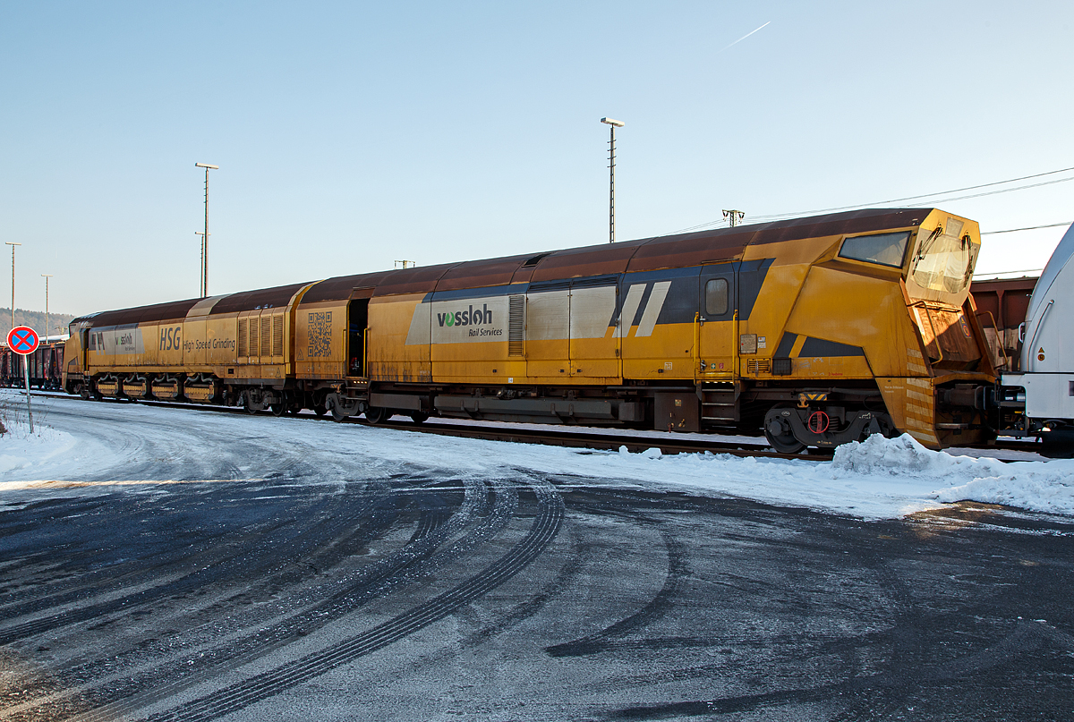 
Der Vossloh Hochgeschwindigkeitsschleifzug HSG - 2 (Vossloh High Speed Grinding), Schweres Nebenfahrzeug Nr. D-VMRS 9980 9527 002-6, der Vossloh Mobile Rail Services GmbH (Bützow), abgestellt am 22.01.2017 beim ICE-Bahnhof Montabaur.

Der Schleifzug wurde von Vossloh unter der Fabriknummer HSG-2-02 im Jahr 2012 gebaut. Die EBA-Nummer ist 10 C04A002.
   
Das Vossloh High Speed Grinding (HSG) ist eine innovatives und neuartiges Schienenschleifverfahren, dessen herausragendes Merkmal die weltweit einzigartige Arbeitsgeschwindigkeit von 80 km/h ist. Dadurch ist die Bearbeitung von Schienen ohne betriebsbehindernde Sperrpausen möglich. Hauptanwendungsbereich ist das präventive Schleifen zur Vermeidung von Rollkontaktschäden und Verriffelung.

TECHNISCHE DATEN:
Spurweite: 1.435 mm
Achsfolge:  unbek.
Anzahl der Achsen: 8 (in 4 Drehgestelle, vom Typ ELH RC25NT)
Länge über Puffer:  37.000 mm (18,50 m / 18,50 m)
Drehzapfenabstand: 2 x 14.600 mm
Achsabstand im Drehgestell: 1.800 mm 
Eigengewicht:  120.000 kg
Nutzlast: 32 t
max. Achslast: 23 t (Zul. Streckenklasse C2/CM2 und höher)
Höchstgeschwindigkeit: 120 km/h (Im Schleifbetrieb 80 km/h)
Motorleistung: unbek.
Laufkreisdurchmesser: 920 m
Kleister befahrbarer Gleisbogen: R 150 m
Zur Mitfahrt zugel. Personen: 5
Max. Anhängelast: - t
Tankinhalt: 3.600 l (Diesel)
Arbeitsrichtung: beidseitig
Anzahl der Schleifsteine: 96

Mit dem Hochgeschwindigkeitsschleifzug HSG-2 ermöglicht Vossloh den Netzbetreibern Schienenpflege im Fahrplan. Der gezielte Abtrag der aufgehärteten Schienenoberfläche mit High Speed Grinding beugt Head Checks oder Verriffelungen vor, und die stufenlose Anpassung der Schleifaggregate bietet eine Optimierung des Schienenquerprofils – bei bis zu 80 km/h Arbeitsgeschwindigkeit!  
Die Absaugtechnik fängt den Materialabtrag auf; die Staubbehälter fassen sechs Tonnen. Der Prozess wird exakt überwacht, und die Arbeitsergebnisse werden dokumentiert. Dank modularer Bauweise lassen sich zudem zwei Schleifzüge zu einer noch leistungsfähigeren twin-Version koppeln.

Prinzip:
High Speed Grinding basiert auf dem Prinzip des Umfangsschleifens, wobei alle Schleifkörper der Maschine passiv angetrieben (durch die Fahrbewegung) und hydraulisch zugestellt werden. Dieses patentierte Verfahren ermöglicht Arbeitsgeschwindigkeiten von bis zu 100 km/h. Der Abtrag von 0,1 mm wird routinemäßig durch drei Überfahrten (2x Schrupp-, 1x Schlichtmodus) sichergestellt.

Maschinenleistung:
Abtrag: ca. 50 µm pro Überfahrt, Rauhigkeit Ra < 8 µm
Arbeitsgeschwindigkeit: 60 bis 100 km/h (Normal 80 km/h)
Reichweite: ca. 100 km pro Schicht
Weichen werden ohne Einschränkung durchfahren, von der Bearbeitung aber ausgespart, Schaltmittel/Bahnübergänge müssen nicht ausgebaut werden.

Einsatzgebiete für das High Speed Grinding sind:
Präventivschleifen:  Vermeidung von Rollkontaktermüdungsschäden durch regelmäßiges Entfernen der ermüdeten Schienenoberfläche, dadurch dauerhaft gute Qualität des Fahrwegs. Der Arbeitsbetrieb erfolgt im Fahrplan. 

Walzhautschleifen: Zweck des Walzhaut- oder Erstlagenschliffs ist die Verzögerung von Riffelbildung sowie die Beseitigung bauseitig entstandener Schienenfehler. Hierbei werden 0,2 bis 0,3 mm von der Schienenoberfläche entfernt, welches in 5 bis 6 Überfahrten bei geringster Baubehinderung geschieht.

Akustikschleifen: Instandhaltung der Fahrflächenebenheit bedeutet, dies bedeutet Reduzierung des durchschnittlichen Schienenlärms durch regelmäßige Schienenpflege, zudem Minimierung von Verriffelungen und Schlupfwellen.

Schmierfilmbeseitigung: Herbstliche, durch Laub verursachte Schmierfilme auf der Schiene führen alljährlich zu erheblichen Betriebsproblemen. Auch andere Schmierfilme, beispielsweise durch Industrieansiedlungen an der Strecke und deren Luftverunreinigungen verursacht, können Probleme bei der Anfahrt oder beim Bremsen verursachen. Zudem kann die Signalgebung beeinträchtigt werden.

Quelle: Vossloh Rail Service GmbH und eigene Sichtung.
