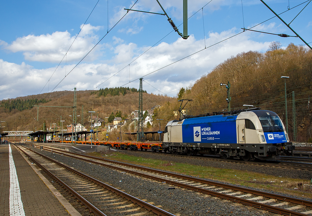 Die 1216 954 (91 81 1216 954-8 A-WLC) der WLC - Wiener Lokalbahnen Cargo GmbH (Wien), fährt am 26.03.2021 mit einem Leerzug, neuer 4-achsiger Drehgestell - 40‘ Containertragwagen der Gattung Sgmmnss 738 der WASCOSA AG Z, durch Dillenburg in Richtung Gießen.

Die Taurus III bzw. Siemens ES 64 U4-C (Variante C für Österreich, Deutschland, Tschechien und die Slowakei) wurde 2010 unter der Fabriknummer 21415 von Siemens gebaut und an die WLC geliefert.
