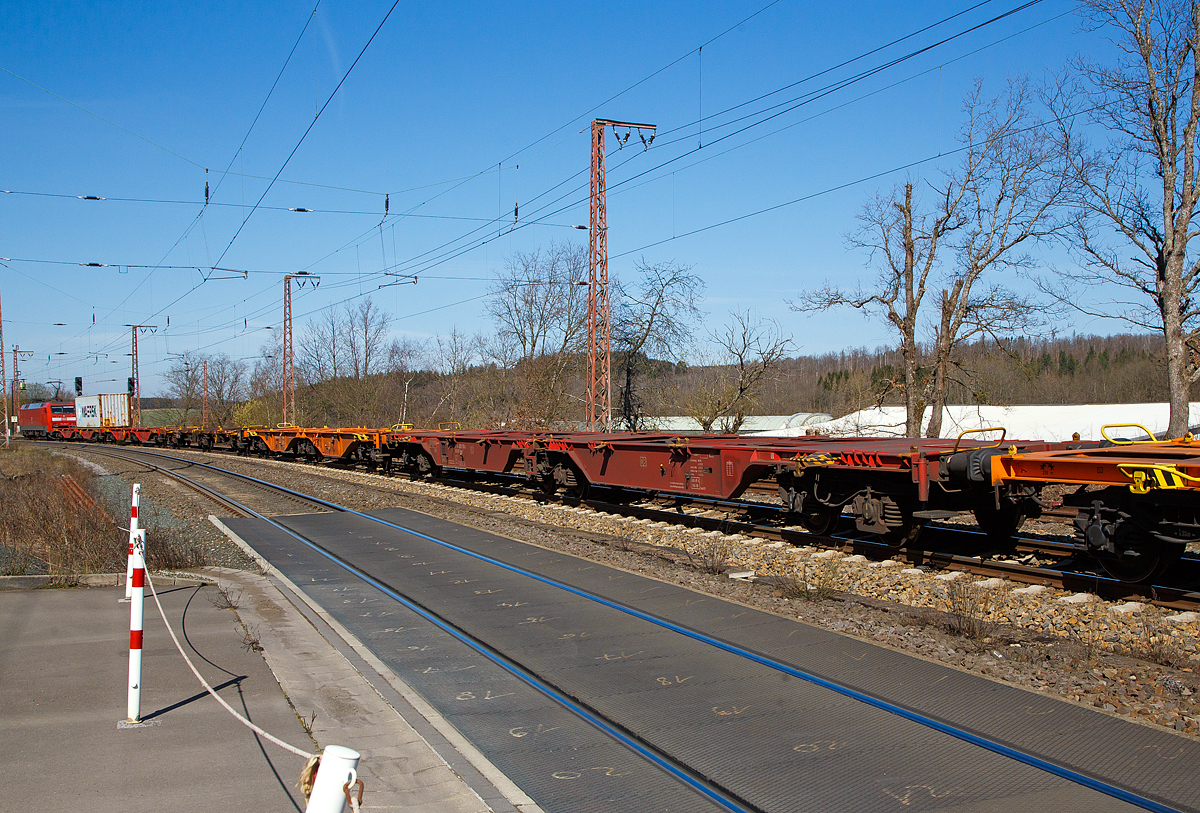 Die 152 124-4 (91 80 6152 124-4 D-DB) der DB Cargo AG erreicht am 30.03.2021 mit einem Containerzug Rudersdorf (Kr. Siegen). Bevor es in Richtung Siegen weitergeht, hat sie hier erst mal Hp 0 und muss den Gegenverkehr abwarten. Ein Gleis war wohl unterbrochen.

Hier im Vordergrund der Sechsachsige Gelenkwagen (Containertragwageneinheit 80´), für den Transport von Großcontainern und Wechselbehältern, 31 80 4850 183-3 D-DB der Gattung Sggrs 716 der DB Cargo AG.

Bei diesem Wagen handelt es sich um einen ursprünglichen 104-Fuß-Wagen der Bauart Sggmrs 715, welcher ursprünglich für kontinentale Wechselbrückenverkehre beschafft wurde. Aufgrund Veränderung der Ladebehälterstruktur im Containerverkehr, wurden 96 dieser Wagen 2017, durch den rumänischen Güterwagenhersteller Astra Rail Industries (seit 2012 zu Greenbrier), in diese Wagen der Bauart Sggrs 716 umgebaut. Der Umbau umfasste hauptsächlich die Kürzung des Wagens von 104 auf 80 Fuß, die Erhöhung der Aufstandshöhe, die Umkonstruktion der seitlichen Abstützung im Bereich der Gelenke sowie den Bremsumbau von Grauguss- (GG) auf innovative lärmarme Kunststoff-Bremssohlen (Cosid 810).

TECHNISCHE DATEN:
Spurweite: 1.435 mm
Länge über Puffer: 26.780 mm
Achsabstand in den Drehgestellen: 1.800 mm
Ladelänge: 2 x 12.250 mm
Höhe der Ladeebene über S.O.: 
Eigengewicht: 28.200 kg
Max. Zuladung bei Lastgrenze S: 104 t (ab Streckenklasse D) 
Max. Geschwindigkeit: 100 km/h (leer 120 km/h)
Kleinster befahrbarer Gleisbogen: R 75 m 
Bremse: 2 x KE-GP-A (K)
Bremssohle: Cosid 810
Feststellbremse: Nein
Verwendungsfähigkeit: RIV