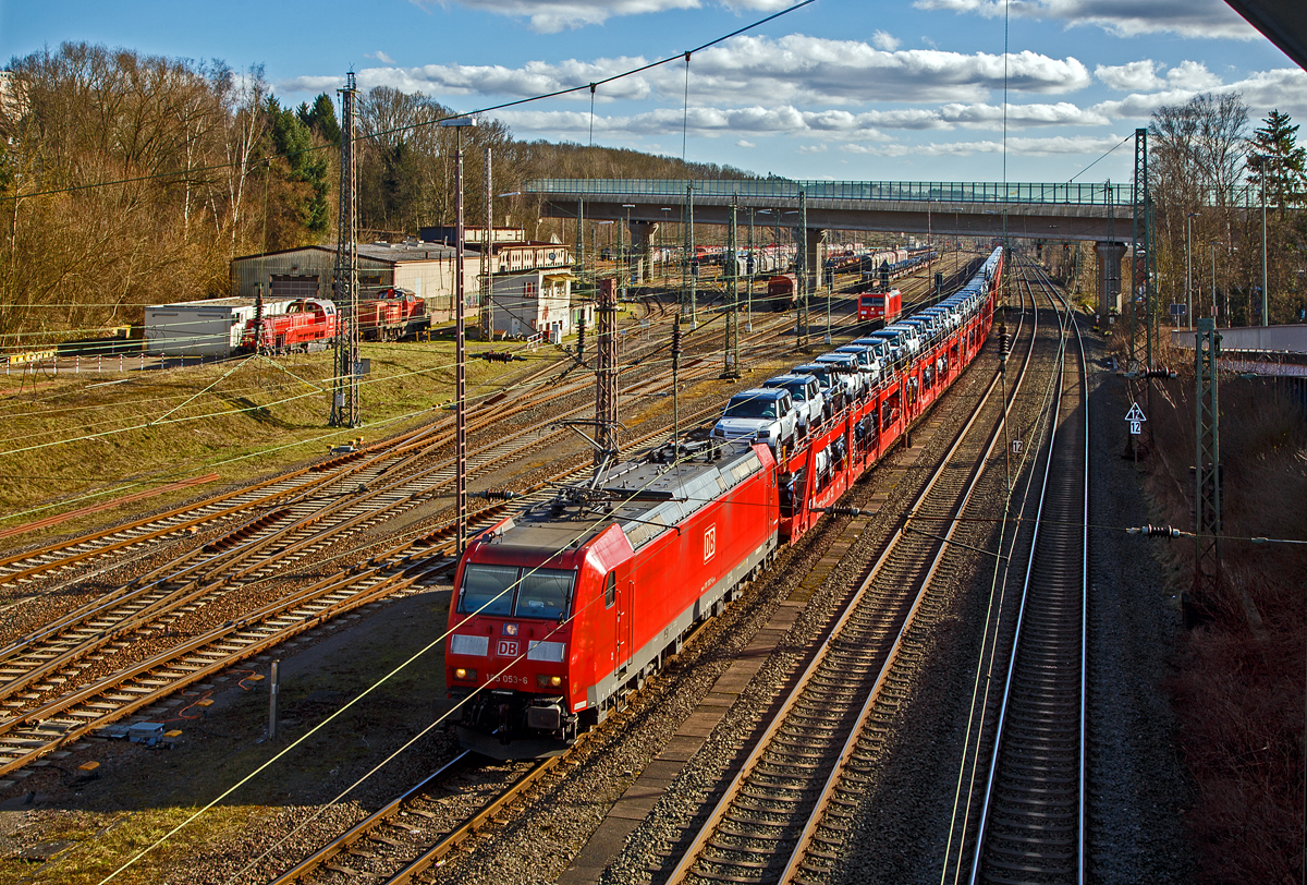 Die 185 053-6 (91 80 6185 053-6 D-DB) der DB Cargo AG, hat am 23.02.2022, mit einem sehr langen Autotransportzug, beim Rbf Kreuztal Hp 0. Der Güterbahnverkehr in Richtung Hagen staute sich etwas in Kreuztal, da die Ruhr-Sieg-Strecke entlang der Lenne (durchs Sauerland) an diesem Tag nur eingleisig befahrbar war. Links der Rangierbahnhof (Rbf) Kreuztal, wo auch u.a. noch die 185 248-2 steht.

Die Wagen von dem Autotransportzug waren Doppelstock-Autotransportwagen der Gattung Laaeffrs 561 (25 80 4382 xxx-x D-ATG) der DB Cargo Logistics GmbH (ex ATG Autotransportlogistic GmbH). 

Die TRAXX F140 AC1 wurde 2002 von Bombardier Transportation GmbH in Kassel unter der Fabriknummer 33461 gebaut.