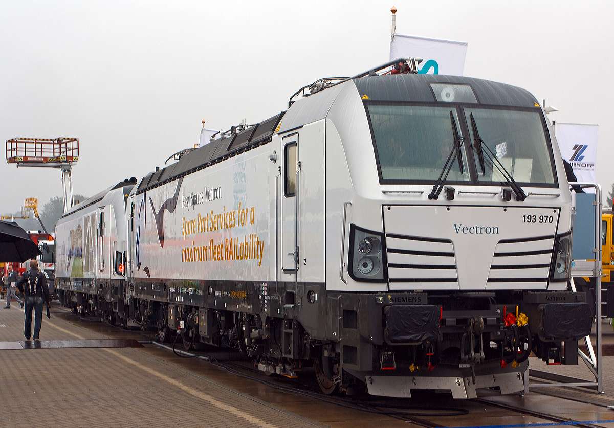 Die 193 970-1 „Easy Spares Vectron  (91 80 6193 970-1 D-PCW) vom Pr�fcenter Wegberg-Wildenrath (Siemens AG) eine Siemens Vectron AC, wurde am Freigel�nde auf der Inno Trans 2014 in Berlin ausgestellt (hier 26.09.2014).  Die Lok wurde 2014 von Siemens in M�nchen unter der Fabriknummer 21924 gebaut und ist in Besitz vom Siemens Rail Systems (Pr�fcenter Wegberg-Wildenrath). Dahinter steht noch die Vectron DE 247 901-2.

Die Entwicklung der Siemens Lokomotive Vectron basiert auf den Erfahrungen der erfolgreichen EuroSprinter und EuroRunner Serien. Ausgereifte und bew�hrte Technik ist mit Flexibilit�t und Modularit�t kombiniert. Die Vectron Lokomotive ist f�r die vielf�ltigsten Verkehrsaufgaben konzipiert. Ob im nationalen oder grenz�berschreitenden Verkehr, ob im Personen- oder G�terverkehr. 

Es werden vier elektrische Versionen und eine dieselelektrische Version der Lokomotivplattform angeboten. Die hier gezeigte Vectron Lokomotive ist als AC – Lokomotive konzipiert mit 6.400 kW und zugelassen f�r Deutschland, �sterreich und teilweise Ungarn, inklusive ETCS.

Technische Daten, der Vectron AC – BR 193
Spurweite: 1.435 mm
Achsformel: Bo'Bo'
L�nge �ber Puffer: 18.980 mm
Drehzapfenabstand: 9.500 mm
Achsabstand im Drehgestell: 3.000 mm
Breite: 3.012 mm
H�he: 4.248 mm
Raddurchmesser: 1.250 mm (neu) / 1.170 mm (abgenutzt)
Gewicht:  87 t
Spannungssysteme: 15 kV, 16,7 Hz und 25 kV, 50 Hz AC
Max. Leistung am Rad:  6.400 kW
Leistungsfaktor:  nahe 1
H�chstgeschwindigkeit:160 km/h
Anfahrzugskraft:  300 kN
Dauerzugkraft:  250 kN
Elektrische Bremskraft: 150 kN
Kraft�bertragung: Ritzelhohlwellenantrieb
Lichtraumprofil: UIC 505-1

Die wurde im Mai 2021 193 970-1 an die Hector Rail AB nach Schweden verkauft, dort tr�gt sie nun die Nummer 243 222-5 (91 74 6243 222-5 S-HCTOR).