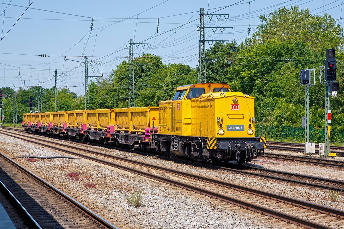Die 203 301-7 (92 80 1 203 301-7 D-DB) der DB Netz AG, , ex DR 110 675-6, ex DR 112 675-4, ex DB 202 675-5, fährt am 04.06.2019 mit einem Aushubzug/Abraumzug (bestehend aus Containertragwagen der Gattung Sgmmns 2 beladen mit je 2 Schmitz Cargobull 20ft. Abraumcontainer) durch den Bahnhof München-Pasing. 

Die V 100.1 wurde 1974 bei LEW (VEB Lokomotivbau Elektrotechnische Werke „Hans Beimler“, Hennigsdorf) unter der Fabriknummer 14376 gebaut und als 110 675-6 an die DR ausgeliefert.

1983 erfolgte der Umbau und Umzeichnung in DR 112 675-4, die Umzeichnung in DR 202 675-5 erfolgte 1992 und ab 01.01.94 dann DB 202 675-5, die Ausmusterung bei der DB erfolgte 2000 und ging dann an SFZ - Schienenfahrzeugzentrum Stendal (heute ALS - ALSTOM Lokomotiven Service GmbH, Stendal), hier erhielt sie einen neuen CAT-Motor und wurde entsprechend in 203 301-7 umbezeichnet. Im Jahr 2001 ging sie dann als 203 301-7  Dieter  an die DB Bahnbau und 2004 an die DB Netz AG.

TECHNISCHE DATEN:
Spurweite: 1.435 mm (Normalspur)
Achsanordnung: B'B'
Höchstgeschwindigkeit: 100 km/h
Kleinste Dauerfahrgeschwindigkeit: 18 km/h
Dienstgewicht: 69 t
Länge über Puffer: 14.240 mm
Radsatzabstand im Drehgestell: 2.300 mm
Drehzapfenabstand: 7.000 mm
Kleinster befahrbarer Gleisbogenradius: 100 m

Motortyp: Caterpillar 3512 B DI-TA
Motorart: 12-Zylinder-Dieselmotor mit Direkteinspritzung, Abgasturbolader und Ladeluftkühlung
Motorleitung: 1.305 kW (1.775 PS) bei 1.600 U/min
Hubraum: 51,8 l (Bohrung-Ø 170 x Hub 190 mm)
Motorgewicht: 6.537 kg
Getriebe: Voith Strömungsgetriebe GSR 30/5,7