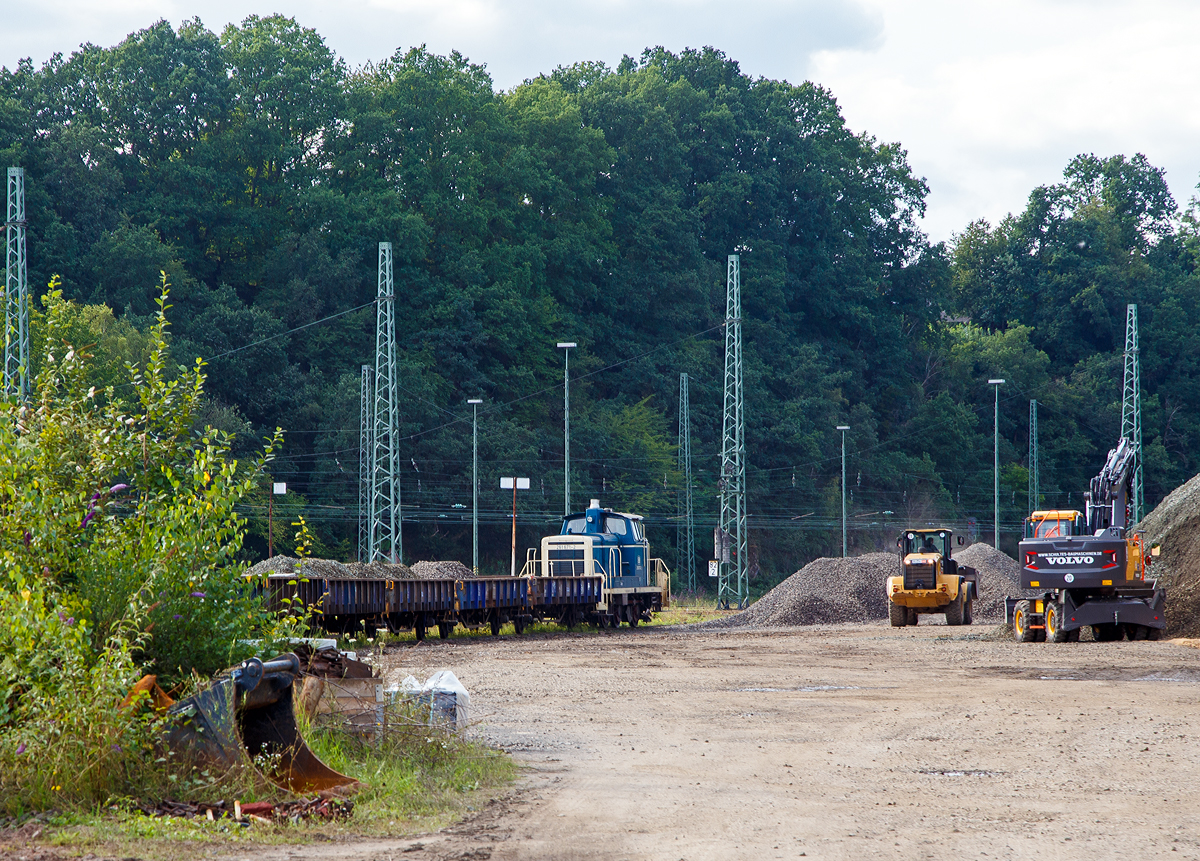 Die 261 671-2 (eigentlich laut NVR-Nummer 98 80 3361 671-1 D-AVOLL) der Aggerbahn (Andreas Voll e.K., Wiehl) steht am 24.08.2021, mit einem Flachwagen-Zug (Niederbordwagen für Schotter und Sand der Gattung Klmos 702), in Betzdorf (Sieg). Der Zug wird hier von einem Radlader mit Schotter beladen. Näher konnte ich nicht heran, da das Betreten der Baustelle verboten war.

Die V60 wurde 1959 von MaK unter der Fabriknummer 600260 als DB V 60 671 gebaut, 1968 erfolgte die Umbezeichnung in DB 261 671-2, 1984 erfolgte schon die Ausmusterung bei der DB.

Die Lok wurde nicht remotorisiert und hat so noch einen originalen gedrosselten Maybach 4-Takt-12-Zylindermotors mit 48 Liter Hubraum vom Typ GTO6A mit einer Leistung von 478 kW (650 PS) bei 1.400 U/min (ungedrosselt 588 kW bzw. 800 PS).