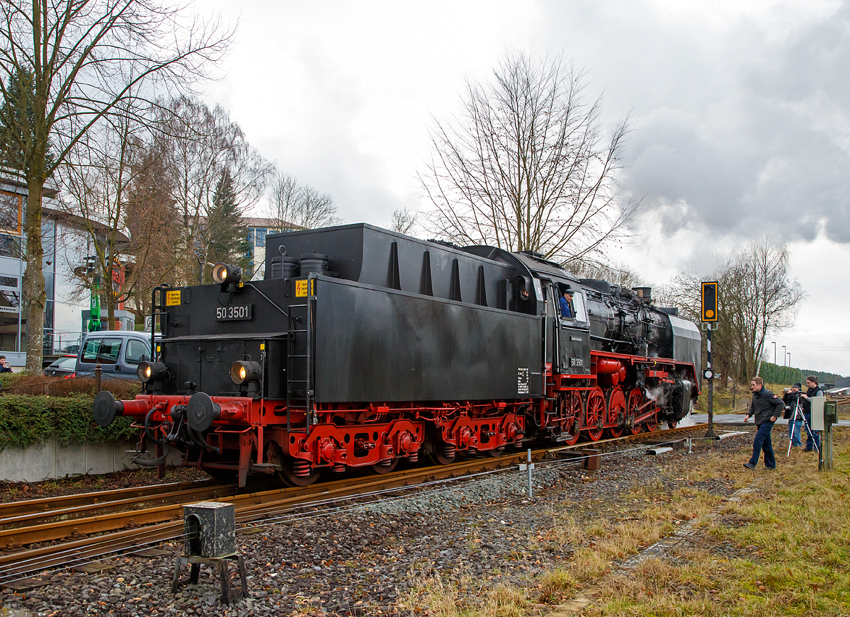
Die 50 3501-9 des Meininger Dampflokwerkes, ex DR 50 3501-9, ex DR 50 380, am 03.02.2018 mit eine Dampfsonderzug der Eisenbahnfreunde Treysa e.V. in Hachenburg (Westerwald). Hier beim Umsetzen.

Die heutige Werkslok des Meininger Dampflokwerkes wurde im Jahre 1940 von den Borsig Lokomotivwerken in Hennigsdorf bei Berlin unter der Fabriknummer 14970 gebaut und als 50 380 an die DRB geliefert. Nach der Rekonstruktion im Raw Stendal am 12.November 1957 wurde sie beim Bw Güsten beheimatet, wo sie elf Jahre, bis Juli 1968 im Einsatz stand. Seit 1971 ist die Lok mit einem Tender vom Typ  2'2' T26 (von Lok 50 3706) gekuppelt, dieser wurde 1941 von der Lokomotivfabrik Jung (Jungenthal bei Kirchen) unter der Fabriknummer 9288 gebaut, dieser war mit der 50 2883 geliefert worden.