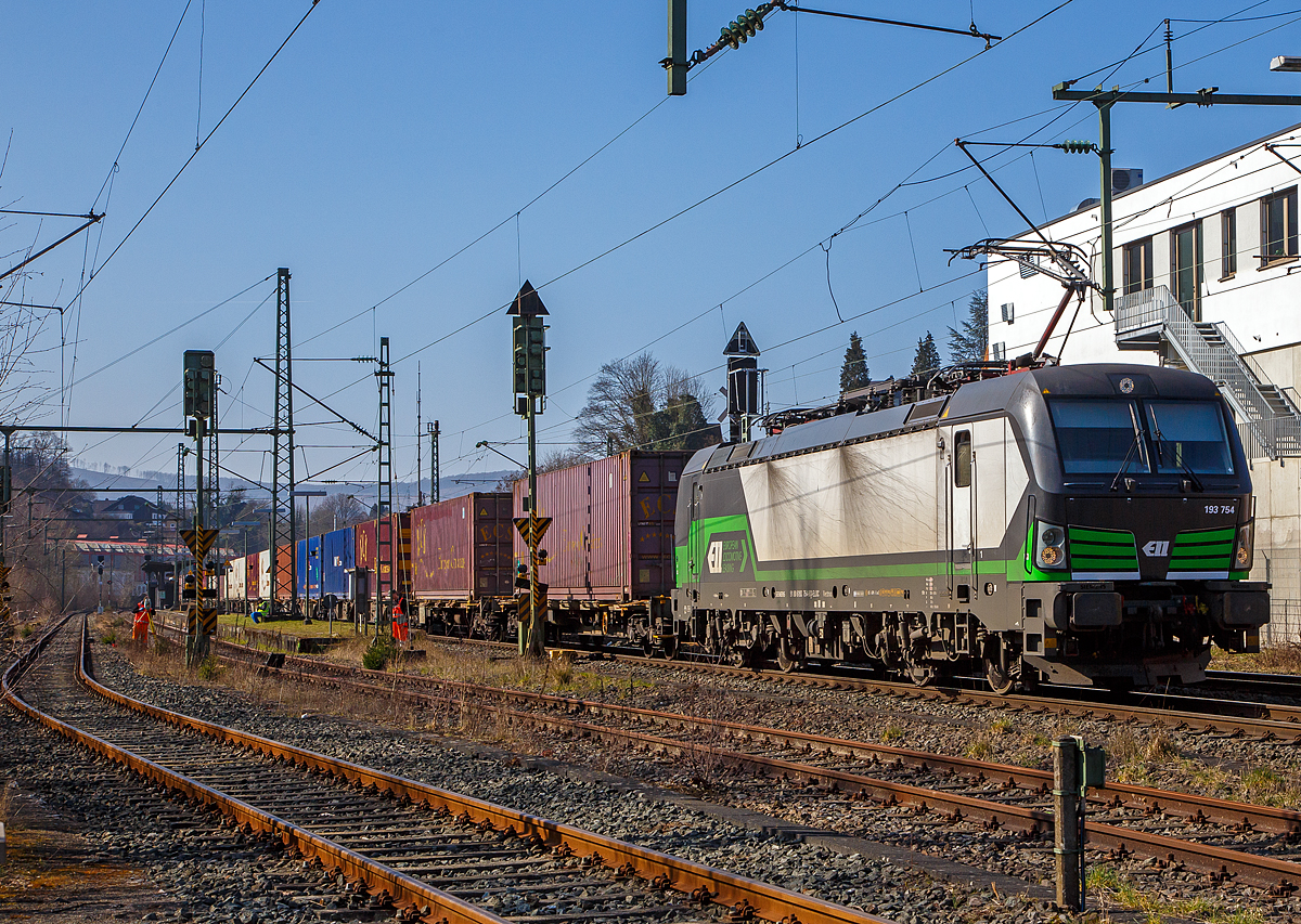 Die an die SETG - Salzburger Eisenbahn TransportLogistik vermietete Vectron MS 193 754 (91 80 6193 754-9 D-ELOC) fährt am 24.03.2021 mit einem KLV-Zug, auf der Siegstrecke durch Niederschelden in Richtung Siegen.

Die Siemens Vectron MS wurde 2019 von Siemens Mobilitiy in München-Allach unter der Fabriknummer 2 2594 gebaut. Sie hat die Zulassungen für Deutschland, Österreich, Ungarn, und die Niederlande (D, A, H, NL). Die Zulassungen für Tschechien, Slowakei, Polen und Rumänien (SK, RO, CZ, PL) sind noch durchgestrichen.
