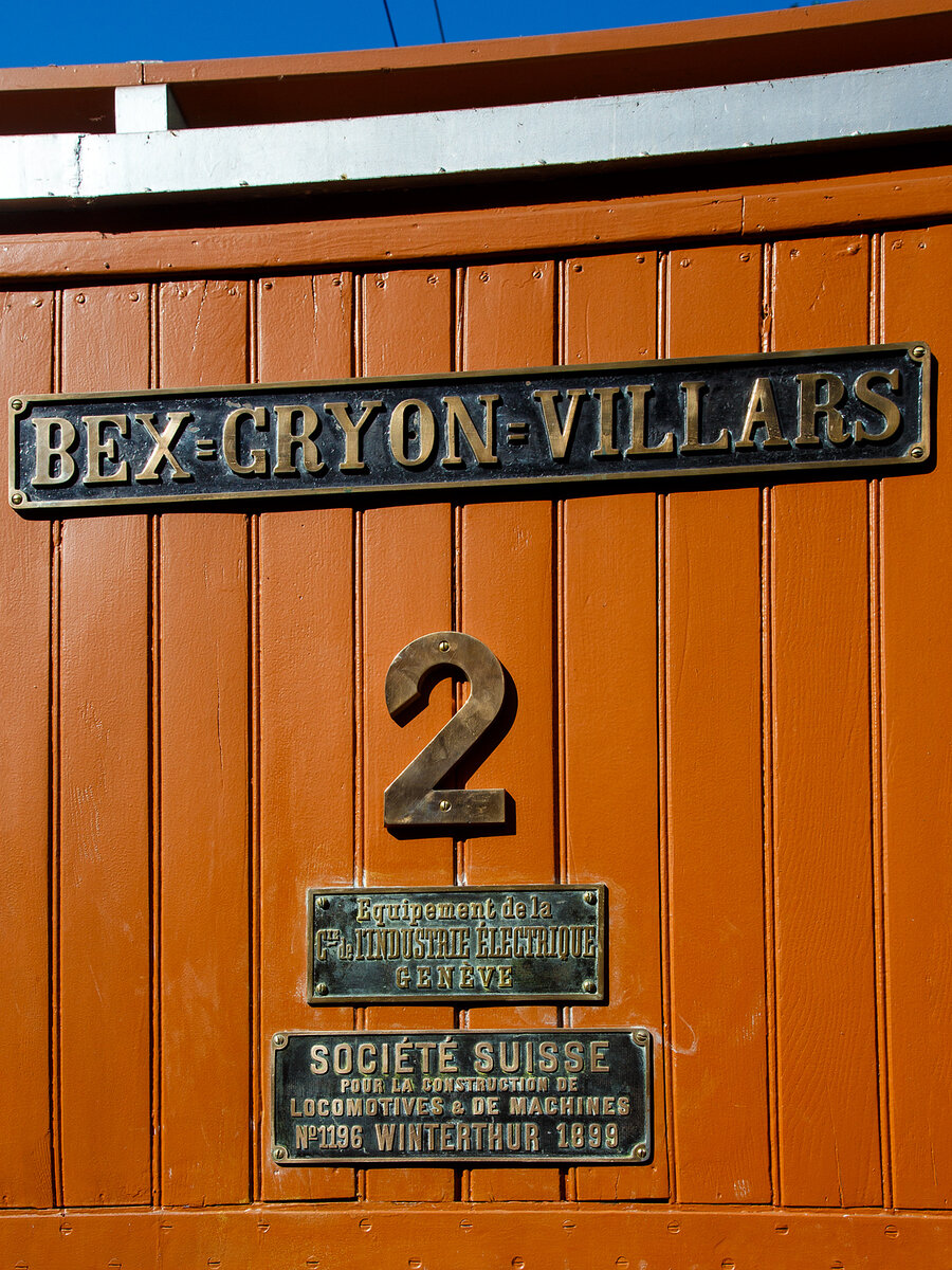 Die Beschilderung der elektrischen Zahnradlokomotive BGV He 2/2 2, später BVB He 2/2 2  La Grisette  der Museumsbahn Blonay–Chamby am 09 September 2023 im Museum Chaulin. Hier mit dem Schild der ehemaligen Chemin de fer électrique Bex = Gryon = Villars (BGV). Und den Fabrikschildern der CIEM - Compagnie de l’industrie électrique et mécanique (ab 1918 SAAS) und der SLM - Schweizerischen Lokomotiv- und Maschinenfabrik in Winterthur (hier in Französisch). 