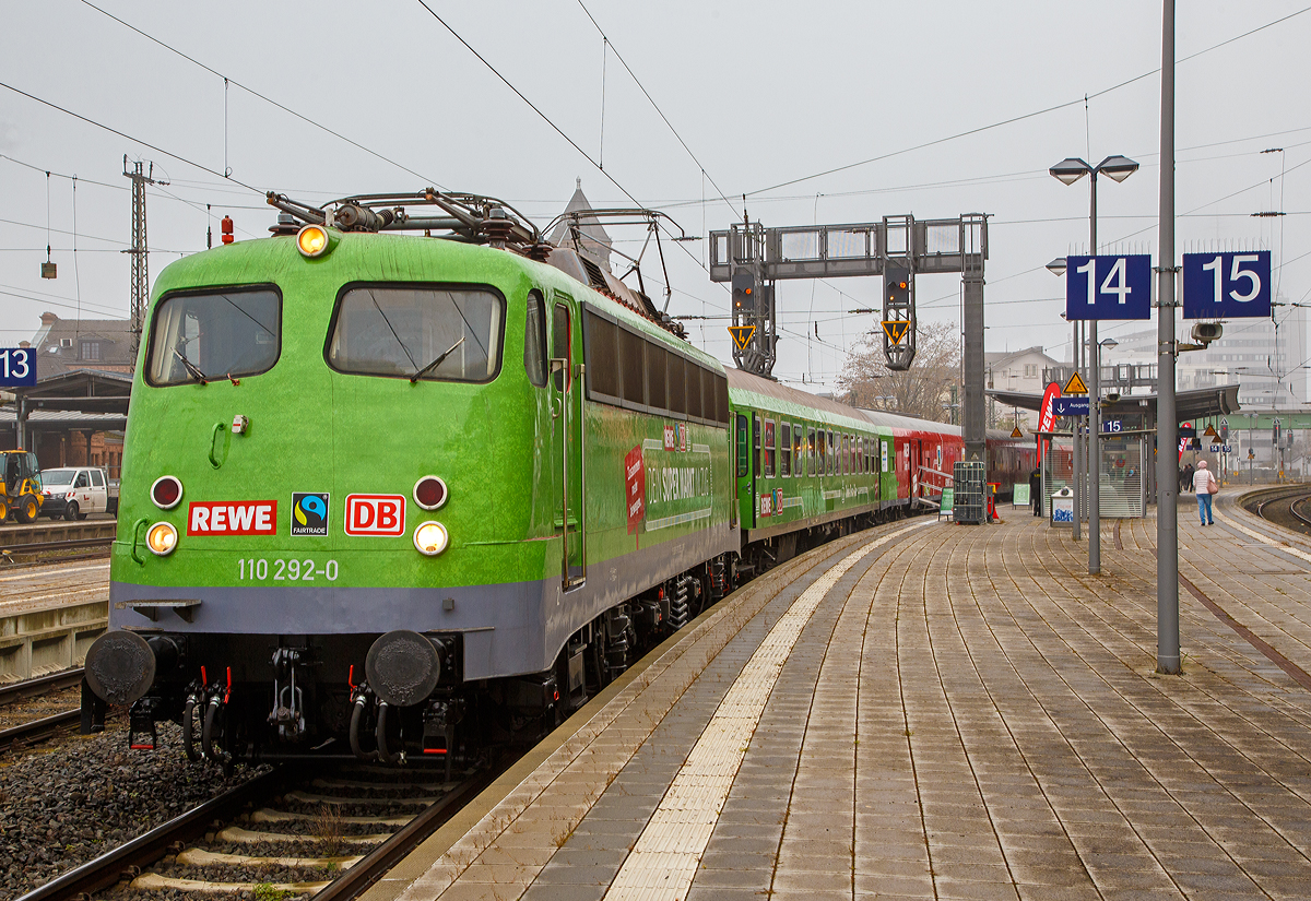 Die B�gelfalten E 10  die 110 292–0 (91 80 6110 292-0 D-GfF) der Gesellschaft f�r Fahrzeugtechnik mbH (bzw. Gesellschaft f�r Eisenbahnbetrieb) steht am 12. und 13.11.2021 (hier 12.11.) mit dem REWE - Supermarkt-Zug im Bahnhof Gie�en.

In Hessen ein zu einem Supermarkt umgebauter Zug in Betrieb genommen worden. Wie die Deutsche Bahn-Tochter DB Regio, der Nahversorger Rewe Region Mitte und der Verein Fairtrade Deutschland mitteilten, werden in dem �Fairen Supermarktzug� k�nftig regionale, �kologische und fair gehandelte Produkte angeboten. Der aus drei Einkaufswaggons, einem Dienstwagen und einem Bord-Bistro bestehende Zug steht an den folgenden Wochenenden (freitags und samstags von 9.00 bis 19.00 Uhr) in den Bahnh�fen Fulda, Kassel, Darmstadt und Wiesbaden. Den �Supermarktzug� f�hren Rewe-Auszubildende.

In Hessen hat Rewe zusammen mit DB Regio eine geniale Idee verwirklicht: Kunden k�nnen hier in einer ganz besonderen Filiale einkaufen. Sie befindet sich im Bahnhof – nicht im Foodcorner, sondern auf der Schiene.

Ach so die Lok hat schon �ber 57 Jahr auf dem Buckel, sie wurde 1964 von Krauss-Maffei in M�nchen-Allach unter der Fabriknummer 18770 gebaut, die Elektrik ist von SSW (Siemens-Schuckertwerke). Sie wurde als E10 292 an die Deutsche Bundesbahn geliefert. Mit der Einf�hrung des EDV-Nummernsystems wurde sie zum 01.01.1968 zur DB 110 292-0, im Jahr 2010 ding sie ins DB-Museum Koblenz-L�tzel, zum 01.01.2021 wurde sie an die GfE Gesellschaft f�r Eisenbahnbetrieb mbH in Crailsheim verkauft.
