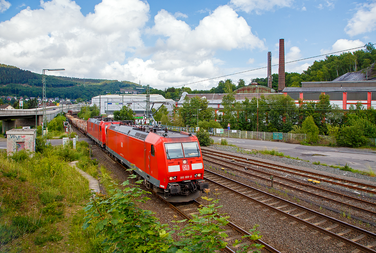 
Die DB Cargo 185 189-8 (TRAXX F140 AC1) und eine kalte 185.2 er (TRAXX F140 AC2) fahren am 02.06.2018 mit einem gem. Güterzug in Richtung Köln, hier zwischen Niederschelden (Nordrhein-Westfalen) und Niederschelderhütte (Rheinland-Pfalz) über die Sieg, die hier Grenzfluss ist.

Hinten rechts im Hintergrund die ehemalige Charlottenhütte (eine ehemalige Eisenhütte).