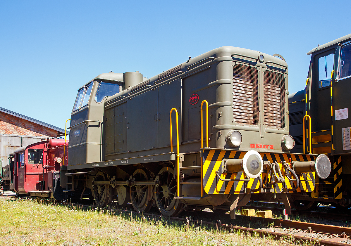 Die Deutz 56341 - eine DEUTZ  V6M 436 R Diesellokomotive, ehemals der Bundeswehr, am 06.05.2018 ausgestellt beim Erlebnisbahnhof Westerwald der Westerwälder Eisenbahnfreunde 44 508 e. V. hier war Museumstag. Die Lok ist Eigentum vom Militärhistorisches Museum Dresden und eine Leihgabe an die Eisenbahnfreunde. In der Lokstation Westerburg findet man eine einzigartige Spezialsammlung von Schienenfahrzeugen der Bundeswehr.

Die Lok wurde 1957 bei Deutz unter der Fabriknummer 56341 gebaut und an die Bundeswehr (Munitionsdepot Nord Löbbersted)  ausgeliefert, 2007 wurde sie außer Dienst gestellt und ging 2008 ans Militärhistorische Museum Dresden.

Nach Beseitigung der schwersten Kriegsschäden war die Klöckner-Humbold-Deutz AG als erste große deutsche Diesellokfabrik ab Anfang 1946 wieder fabrikationsfähig. Zunächst konzentrierte man sich auf die Fertigstellung bereits begonnener Fahrzeuge. Nach der Produktionsfreigabe durch die Besatzungsmächte begann man auch wieder mit Neuanfertigungen. Hierbei orientierte man sich weitgehend an der bewährten Wehrmachtslokomotive WR 360, die bis 1954 nahezu unverändert, ab 1952 als V6M536R mit gerundeten Formen und ab 1954 als V6M436R und V6M536R mit völlig neuem Aussehen des Aufbaus angeboten wurde. Bis 1960 konnte Deutz von diesen V 36-Nachbauten insgesamt 34 Stück verkaufen, eine davon ist die Lokomotive 56341 des ehemaligen Munitionsdepots Lübberstedt.

Der Typenreihe KHD V6M436 wurde die Versorgungsnummer 2210-12-120-5654 zugeordnet.

In der Erfolgsbilanz der Lokomotiv - Lieferanten für die Bundeswehr steht die KHD - Klöckner-Humboldt-Deutz AG, Köln an erster Stelle, auch wenn es bei der KHD V6M 436 R in der 440 PS-Klasse bei diesem Einzelstück blieb. Im Rahmen der schon erwähnten Ausschreibung bot KHD 1956 eine V6M 436 R zum Stückpreis von DM 335.620,-- an. Die Auftragserteilung erfolgte im August 1956, der schon am 03.03.1957 die Auslieferung an das Munitionsdepot Lübberstedt folgte. Die Lokomotive ist seit der Inbetriebsetzung stets im MunDepot Lübberstedt im Einsatz gewesen. 

Nennenswerte Ausfälle der Lokomotive traten in den Jahren 1994 und 1998 jeweils durch Motorschäden auf. Aber auch hier gelang der MaK - Rahmenvertragswerkstatt Moers stets die Instandsetzung des Fahrzeuges, obwohl die entsprechenden Originalersatzteile nicht mehr verfügbar sind. Die letzten Hauptuntersuchungen wurden in den Jahren 1978, 1986 und 1993 in Moers durchgeführt. Infolge eines neuerlichen Motorschadens kam die Lok am 29.06.1998 in die Moerser Werkstatt, auch diesmal gelang es den Schaden zu beheben. Nach einem 16-monatigen Werkstattaufenthalt hat sie mit HU-Datum vom 21.10.1999 wieder den Weg zum Munitionsdepot Lübberstedt angetreten. Mit Fristablauf Oktober 2008 wurde die Maschine abgestellt und wegen der Schließung des Depots die Aussonderung vorbereitet. Das Militärhistorische Museum Dresden übernahm diesen technischen Zeitzeugen und übergab die Lok in die Spezialsammlung der WEF 44 508 e. V. in Westerburg. Am 23.12.2008 erreichte die Maschine den Erlebnisbahnhof Westerwald und kann seitdem von der Allgemeinheit besichtigt werden. Die Westerwälder Eisenbahnfreunde haben viele Mühen für die Erhaltung der Lokomotive auf sich genommen, schließlich ist sie das weltweit einzige noch betriebsfähige Exemplar

Quelle: http://www.bundeswehrloks.de/

Technik:
Die DEUTZ V6M 436 R ist eine dieselhydraulische, dreiachsige Starr-Rahmen-Lokomotive mit Endführerhaus. Die Kraftanlage besteht aus dem Deutz-6-Zylinder-Dieselmotor V6M 436 (360PS), der über eine elastische Kupplung das Flüssigkeitsgetriebe antreibt. Das verwendete Flüssigkeitsgetriebe ist ein Voith-Turbogetriebe der Type L 37U. Es besteht aus einem hydraulischen Drehmomentwandler und zwei hydraulischen Kupplungen mit selbsttätig wirkender Steuerung. Diesem Getriebe ist ein kombiniertes Stufen- und Wendegetriebe nachgeschaltet, in dem auch die Blindwelle gelagert ist. Von der Blindwelle aus werden die drei Radsätze mit Treib- und Kuppelstangen angetrieben.

Für das Starten des Motors, der mittels Druckluft angelassen wird, sind zwei Luftflaschen mit je 250 Litern Volumen vorhanden. Die Kühlanlage besteht aus dem Wasserkühler, dem Getriebeölkühler, dem Kühler für das Motorschmieröl und dem Lüfterrad. Die Lok besitzt außer der 6 - Klotz - Handspindelbremse eine durchgehende Druckluftbremse für Lokomotive und Zug sowie eine Druckluftzusatzbremse nur für die Lokomotive.

Die Beleuchtungsanlage der Lok wird aus einer Batterie gespeist, die durch eine ständig vom Motor angetriebene Lichtmaschine geladen wird. Die Lokomotive hat ein Dienstgewicht von etwa 42 Tonnen und erreicht auf gerader horizontaler Strecke im Verschiebedienst eine Maximalgeschwindigkeit von 34 km/h, sowie im Streckendienst von 51 km/h. 

Technische Daten:
Typ:  V6M 436 R (Bauform 1954)
Spurweite: 1.435 mm (Normalspur)
Länge über Puffer:   9.570 mm
Achsanzahl:  3 (C-dh)
Motor:  KHD wassergekühlter 6 Zylinder Reihenmotor
Mit 97,68 l Hubraum (vom Typ V6M 436 R)
Leistung: 360 PS bei 600 U/min
Getriebe: Voith-Turbo-Getriebe L 37 U
Antriebübertragung: s.o.
Dienstgewicht:  42 t
Höchstgeschwindigkeit: 51 km/h
Raddurchmesser  1.100 mm
Anfahrzugkraft  129,5 kN
Bremse:  Knorr Druckluftbremse
