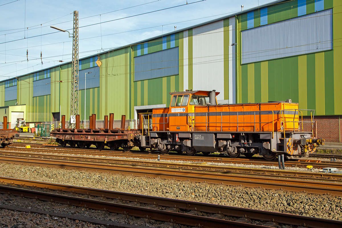 Die DEW 7 (Lok 7 der Deutschen Edelstahlwerke GmbH), zuvor Edelstahlwerke Südwestfalen, rangiert am 26.10.209, mit einem sechsachsigen Drehgestellflachwagen am Haken, vom Anschlussgleis zurück aufs Werksgelände in Siegen-Geisweid.

Die Lok ist eine Mak G 1203 BB und wurde1986 unter der Fabriknummer 1000808 in Kiel gebaut und an die Krupp Stahl AG, Werk Siegen-Geisweid, gelieferet. 

Die Lokomotive MaK G 1203 BB ist eine dieselhydraulische Lokomotive, die von der Maschinenbau Kiel (MaK) gebaut wurde, die Achsfolge ist B’B’. Sie erreicht eine maximale Geschwindigkeit von bis zu 70 km/h. Eingebaut wurden Motoren von MTU (745 kW) und für sechs Exporte nach Gabun mit amerikanischen Cummins-Motoren (761 kW). Die MaK G 1203 BB wurde zwischen 1982 und 1991 in 25 Exemplaren gebaut. Sie gingen an 14 verschiedene Eisenbahnbetreiber in Deutschland. Eine Lok ging nach Schweden und sechs nach Gabun .

Im Deutschen Fahrzeugeinstellungsregister wurde für diese Bauart die Baureihennummer 98 80 0273 vergeben.

TECHNISCHE DATEN:
Spurweite: 1435 mm
Achsfolge: B´B´
Länge über Puffer 12.500 mm
Drehzapfenabstand: 5.800 mm
Achsabstand im Drehgestell: 2.400 mm
größte Breite: 3.100 mm
größte Höhe über Schienenoberkante: 4.220 mm
kleinster befahrbarer Gleisbogen: 60 m
Dienstgewicht: 88 t
Kraftstoffvorrat: 2500 l
Motor : MTU, Typ 8V 396
Leistung: 745 kW
Drehzahl: 1800 1/min
Getriebe: Voith, Typ L4r4zU2     
