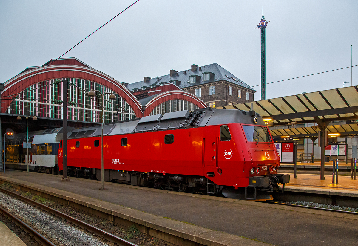 
Die DSB ME 1521 (92 86 0001 521-0 DK-DSB) steht am 22.03.2019, als Schublok mit einem Doppelstock-Regionalzug, im Hauptbahnhof Kopenhagen (K�benhavns Hovedbaneg�rd) zur Abfahrt bereit.

Die Lok wurde 1983  von Thyssen-Henschel in Kassel unter der Fabriknummer 32634 gebaut, der Lokkasten ist von Scandia A/S in Randers und die elektrische Ausr�stung von BBC (Brown, Boveri & Cie.).

Die Lokomotiven Baureihe ME (II) mit dieselelektrischer Leistungs�bertragung bilden die neueste Baureihe von Diesellokomotiven f�r den Streckendienst der Danske Statsbaner (DSB). In zwei Bauserien wurden insgesamt 37 Exemplare f�r die DSB hergestellt.  F�nf technisch �hnliche Maschinen gingen an die Norwegischen Staatsbahnen (NSB) als Baureihe Di.

Die Lokomotiven haben eine im unteren Bereich abgekantete Stirnfront mit einteiliger Frontscheibe, die Seitenw�nde sind glatt und leicht bauchig, der Maschinenraum besitzt auf jeder Seite vier Fenster. Zwischen Dach und Seitenwand ist eine Dachschr�ge. Vorne haben die Lokomotiven ein gro�es Schneer�umschild, an der Seite Blinkleuchten zur Anzeige der Abfahrbereitschaft. Die Lokomotiven sind mehrfachtraktions- und wendezugf�hig

Die DSB interessierte sich in den 1970er Jahren f�r Drehstromlokomotiven, bei denen sich der Dieselmotor ggf. gegen eine elektrische Anlage tauschen lie�. So sollten die Maschinen bei einer sp�teren Elektrifizierung der Hauptstrecken weiterhin nutzbar bleiben. 1977 wurde in D�nemark die DB-Experimentallok 202 004 vom Typ DE 2500 erprobt, die sich trotz geringerer Nennleistung gegen�ber der Baureihe MZ I/II mit besseren Lauf- und Traktionseigenschaften auszeichnete. Die DSB orderte daraufhin 1979 die Baureihe ME, die in Kombination mit den Typen MY, MX, MZ und EA betrieben werden konnte. Als Hauptauftragnehmer trat Thyssen-Henschel in Kassel auf, die elektrische Ausr�stung kam von BBC, die Dieselmotoren von GM und die Wagenk�sten wurden bei Scandia in Randers gebaut. Die Auslieferung der ersten MEs verz�gerte sich, so dass Henschel 1981 f�r einige Monate von der DB insgesamt 18 Loks der Reihe V 200 lieh, die von der DSB westlich des Gro�en Belts eingesetzt wurden. 

Die MEs wurden zun�chst im IC- und Nahverkehr auf Seeland und Lolland-Falster sowie vor internationalen G�terz�gen eingesetzt. Seit 1997 sind sie als einziger Dieselloktyp f�r Reisez�ge auf der Store B�lt- -Querung zugelassen.

TECHNISCHE DATEN:
Anzahl: 37
Hersteller: Thyssen-Henschel, Scandia , BBC
Spurweite: 1.435 mm (Normalspur)
Achsfolge: Co’Co’
L�nge �ber Puffer : 21.000 mm 
Drehzapfenabstand: 11.550 mm
Achsabstand im Drehgestell:  2.000 + 1.850 mm
H�he: 4.350 mm
Breite: 3.150 mm
Treibraddurchmesser: 	1.100 mm (neu)
Dienstgewicht: 115 t 	
Motor: EMD 16-645 E3B, 16-Zylinder-Zweitakt-Dieselmotor
Leistung: 2.426 kW (3.300 PS) bei 900 U/min
Anfahrzugkraft: 	360 kN
Anzahl der Fahrmotoren: 6 asynchrone Dreiphasen-Wechselstrommotore
Kraft�bertragung: dieselelektrisch (Dieselmotor auf Generator, dieser liefert dann die elektrische Energie f�r die 6 Fahrmotoren)	
H�chstgeschwindigkeit : 175 km/h 	
Kupplungstyp:  Schraubenkupplung
