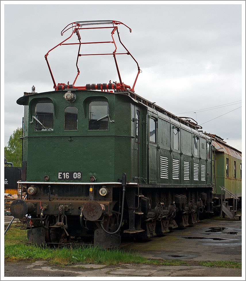 Die E 16 08, ex DB 116 008-4, ex DRG E 16 08, am 28.04.2013 m Eisenbahnmuseum in Darmstadt-Kranichstein. 

Die eigentlich Bayerische ES 1 wurde 1926/1927 von Krauss & Co. (später Krauss-Maffei) unter der Fabriknummer 8173 und der elektrische Teil von BBC unter der Fabriknummer 5046 gebaut.

In den Alpen wurde schon früh die Wasserkraft zur Gewinnung elektrischer Energie ausgenutzt. Die Anwendung des elektrischen Stromes bei der Eisenbahn führte zu den ersten Elektrifizierungen von Eisenbahnstrecken in Bayern. Die ersten elektrischen Lokomotiven wiesen einen Stangenantrieb auf. Eine weitere Steigerung der Geschwindigkeit über 100 km/h ließ sich mit der Technik des Stangenantriebs nicht mehr erreichen.

Die kgl. bayerische Staatsbahn befasste sich daher schon vor dem ersten Weltkrieg mit der Entwicklung einer elektrischen Schnellzuglokomotive, die Einzelachsantrieb erhalten sollte. Beim Einzelachsantrieb wird gegenüber dem Stangenantrieb, wo ein großer Motor die Kraft über mit Stangen gekuppelte Radsätze verteilt, auf jeder angetriebenen Achse ein separater Motor angeordnet. Dieser Antrieb hat den Vorteil, durch kleine Bauteile höhere Drehzahlen und damit höhere Geschwindigkeiten zu erreichen. Hierbei galt es, eine konstruktive Lösung zu finden, die den gefederten Radsatz mit dem ungefederten im Lokrahmen ruhenden Motor verbindet. Die Ereignisse des ersten Weltkrieges unterbrachen diese Entwicklung. Als sie nach dem Krieg fortgeführt wurde, war für Schweizer Lokomotiven von der Firma BBC der sogenannte Buchli-Antrieb eingeführt worden, der sich im Betrieb gut bewährte.
Der Buchli-Antrieb ist die Technische Besonderheit der Lok, bei dem hochliegende Motoren über ein außenliegendes Getriebe nur eine Seite der Treibachsen antreiben, die gegenüberliegende Seite ist antriebslos. Daher hat eine E 16 zwei unterschiedliche Ansichtsseiten, bei einer blickt man auf den Buchli-Antrieb, bei der anderen auf die blanken Speichenräder. Die E 16 ist die einzige deutsche Lokomotivbaureihe mit dem Buchli-Antrieb. 
Der einseitige Buchli-Antrieb bewährte sich ausgezeichnet, weshalb seitens der Deutschen Reichsbahn im Jahre 1931 noch 4 Lokomotiven dieser Baureihe nachbestellt wurden, die eine um etwa 10% höhere Leistung aufwiesen.

Zur Erzielung eines guten Laufverhaltens und zur Einhaltung der zulässigen Achslasten ist vorne und hinten jeweils eine nicht angetriebene Laufachse angeordnet, die mit der benachbarten Antriebsachse zu einem Drehgestell der Bauart Krauss-Helmholtz vereinigt wurde. Diese Laufwerksanordnung hat sich in 50 Betriebsjahren hervorragend bewährt. 

Während ihrer gesamten Einsatzzeit waren diese Lokomotiven in Bayern stationiert. Als eine der letzten Lokomotiven dieser Baureihe wurde die E 16 08 am 23.3.1978 außer Dienst gestellt. Im Jahre 1968 erhielt sie noch die computergerechte neue Betriebsnummer 116 008-4. Die Lokomotive ist bis zu ihrer Ausmusterung insgesamt 4,5 Millionen km gelaufen. Nach der Ausmusterung wurde sie nicht zerlegt, sondern für die Sammlung des Verkehrsmuseums Nürnberg im AW München-Freimann abgestellt. Da dort ihr Abstellplatz anderweitig benötigt wurde, erhielt das Eisenbahnmuseum Darmstadt-Kranichstein die Lokomotive seit dem 26.4.1988 als Dauerleihgabe zur Betreuung und zur Ergänzung der eigenen Sammlung.

Technische Daten:
Bauart: 1'Do 1' 
Höchstgeschwindigkeit:  120 km/h
Kuppelraddurchmesser :  1.640 mm
Dienstgewicht: 110,8 t
Länge über Puffer:  16.300 mm
Stundenleistung:  2.340 kW
Dauerleistung:  2.020 kW
Größte Anfahrzugkraft:   14.500 kg
Antriebsbauart:  Buchli
Zahl der Dauerfahrstufen   18
Gebaute Loks: 21
