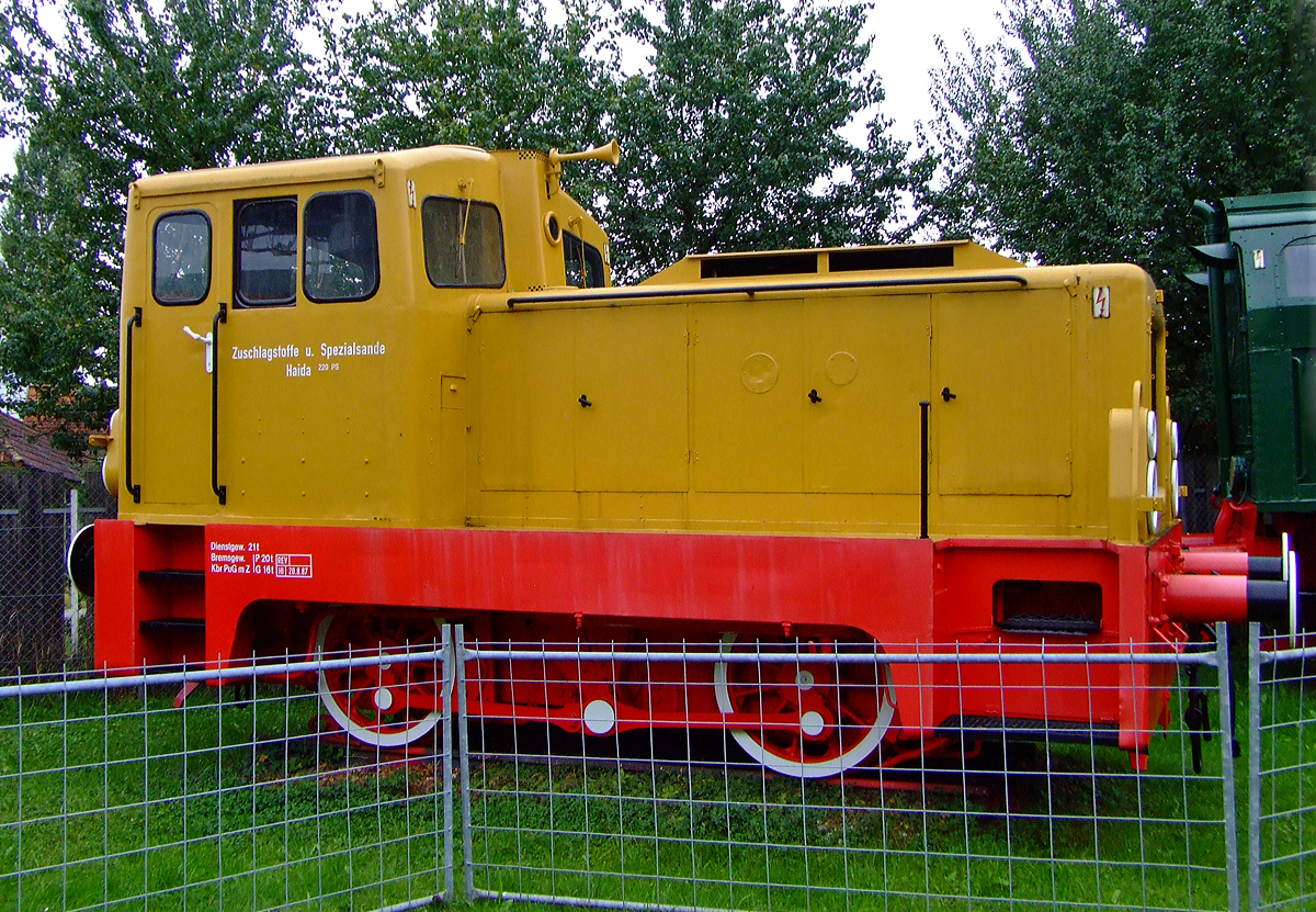 Die ehemalige Lok 3 der ZuS - Zuschlagstoffe und Spezialsande GmbH (Haida), ex Lok 4 der CFK – VEB Chemiefaserkombinat Wilhelm-Pieck-Stadt Guben, eine LKM V 22 B (ex LKM V 18 B) am 02.10.2010 im Technik Museum Speyer.

Die normalspurige Lok wurde 1963 bei VEB Lokomotivbau Karl Marx Babelsberg (LKM) unter der Fabriknummer 261319 als Typ V 18 B gebaut. Die LKM ging �brigens aus dem Werk der Maschinenbau und Bahnbedarf Aktiengesellschaft, vormals Orenstein & Koppel, Berlin (MBA) hervor.  1987 erfolgte ein Umbau, durch die Ausr�stung mit einem 220 PS-Dieselmotor 6 VD 18/15-1 und Str�mungsgetriebe GSU 20/4.2 durch das RAW Halle der Deutschen Reichsbahn. Somit erfolgte die neue Typenbezeichnung V 22 B.

Mit Serienreife der V 15 stand ein leistungsst�rkerer Motor zur Verf�gung, so da� dieser in die Serienfertigung einfloss. Nach Anpassungen am Str�mungsgetriebe wurde die 180 PS leistende Lokomotive als V 18 in einer St�ckzahl von 577 Exemplaren in der Zeit von 1961 bis 1967 gebaut. Zahlreiche V 18 wurde auch an Industrie- und volkseigene Betriebe in der DDR geliefert. Danach wurde eine weitere Leistungssteigerung im Serienbau umgesetzt, so da� die weitere Fertigung auf eine 220 PS leistende Lok (V 22 B) �berging.

Bei anstehenden Revisionen wurden im Rahmen von Vereinheitlichungsbestrebungen Motor und Getriebe bei vielen Fahrzeugen der Baureihe V 18 gegen die Komponenten der V 22 genannte leistungsst�rkere Varianten getauscht. Dieser Tausch wurde als Umbau auf den Fabrikschildern der V 18 vermerkt.
TECHNISCHE DATEN:
Spurweite:  1.435 mm
Achsfolge: B
L�nge �ber Puffer:  6940 mm
Achsstand:  2.500 mm
Raddurchmesser neu:  1.000 mm
Dienstgewicht:  21t
Leistung:  136 kW/180 PS als V 18 (sp�ter 162 kW/220 PS als V 22)
H�chstgeschwindigkeit:  37 km/h

Der Kraftfluss erfolgt vom Motor �ber eine drehelastische Kupplung und eine kurze Gelenkwelle zum Antrieb des Str�mungsgetriebes GSR 12/3,7 mit einem Wandler und zwei Kupplungen. Sp�ter wurde das Zweiwandlergetriebe GSU 20/4,5 mit Anfahrwandler (bis 16 km/h) und Marschwandler (f�r 16–40 km/h) eingebaut. Das Umschalten der Getriebe erfolgt selbstt�tig, in Abh�ngigkeit von der Fahrgeschwindigkeit.

An das Str�mungsgetriebe ist das Wendegetriebe direkt angeflanscht, das den Wechsel der Fahrtrichtung erm�glicht. Die Wendegetriebe wurden im Laufe der Zeit mehrfach �berarbeitet und verbessert. Das Wendegetriebe treibt die Blindwelle direkt an und �bertr�gt das Drehmoment �ber Kuppelstangen auf die beiden Rads�tze. 
