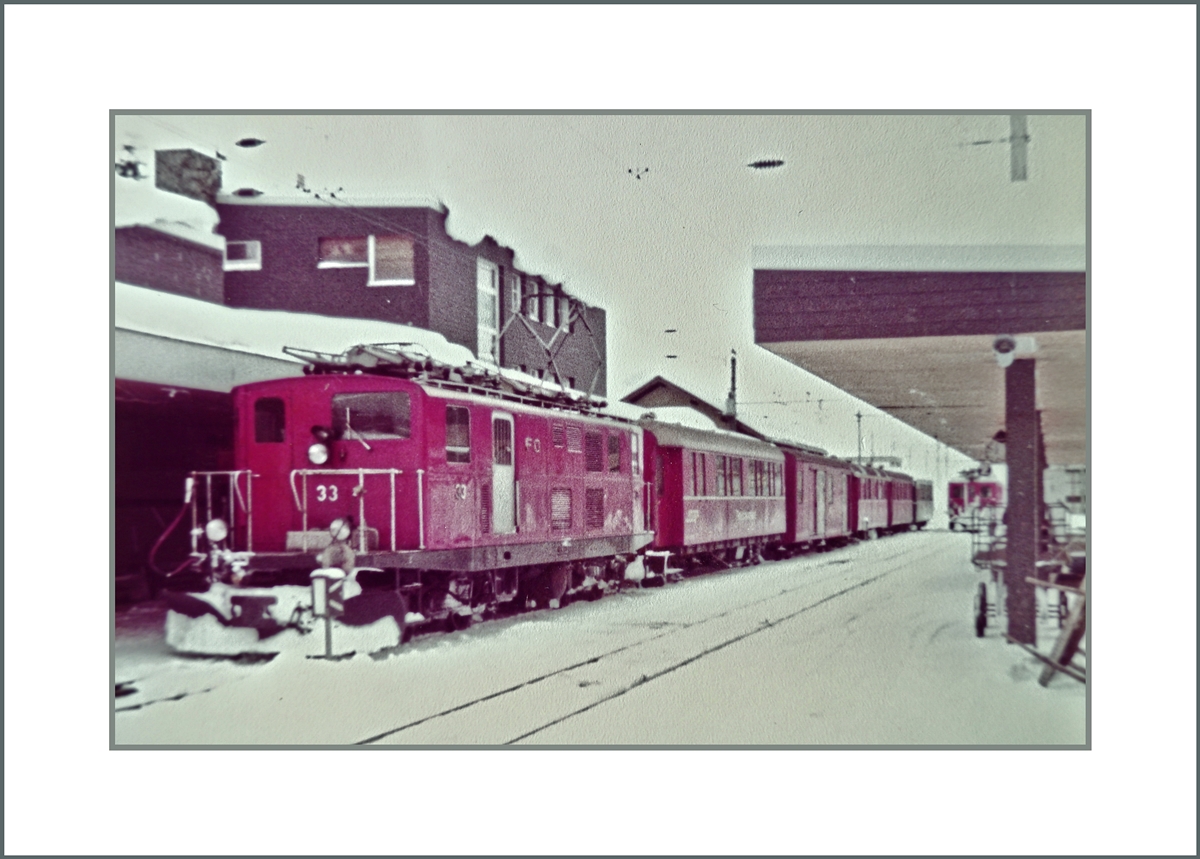 Die FO HGe 4/4 I N° 33 wartet in Andermatt auf  die Abfahrt nach Disentis.
Fotografiertes 110-Film Bild; 13. März 1982