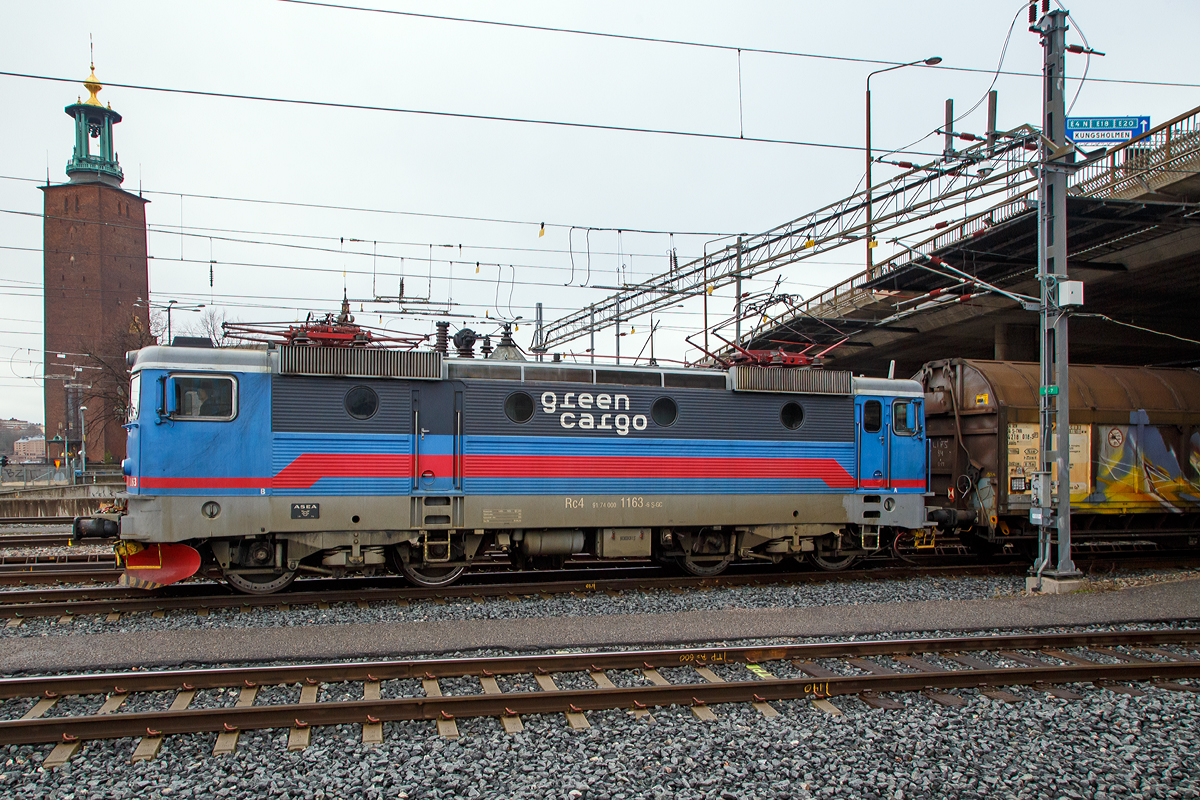 
Die Green Cargo  Rc4 1163 (91 74 000 1163-6 S-GC) fährt am 21.03.2019 mit einem Güterzug durch Stockholm Central.

Die Rc4 wurde 1976 von ASEA unter der Fabriknummer 1789 gebaut und an die SJ geliefert.

Die Baureihe SJ Rc ist eine für die schwedische Staatsbahnen Statens Järnvägar (SJ) von ASEA zwischen 1967 und 1988 gebaute Elektrolokomotive. ASEA (Allmänna Svenska Elektriska Aktiebolaget) war ein schwedisches Elektrotechnikunternehmen, 1988 legte der Konzern sein Geschäft mit der Schweizer BBC (Brown, Boveri & Cie) zur Asea Brown Boveri (ABB) mit Hauptsitz in Zürich zusammen.

Die Rc Lokomotiven waren die ersten thyristorgesteuerten Serien-E-Loks in Schweden. Mit 366 in verschiedenen Varianten (Rc1 bis Rc7, sowie Rm) hergestellten Exemplaren ist die Baureihe die in Schweden am meisten verbreitete Lokbaureihe. Der Vorgänger der Rc-Lokomotiven war eine umgebaute RB-Prototyplok. Vorteil der thyristorgesteuerten E-Loks ist der Einsatz von Gleichstrommotoren mit Stufenschalter und Diodengleichrichter, anstelle von Wechselstrommotoren. Ein Problem bei thyristorgesteuerten Rc-Lokomotiven besteht darin, dass sie starke Störungen im Fahrdrahtnetz verursachen.

Der Lokkasten ist eine geschweißte, selbsttragende Konstruktion. Die Seitenwände sind mit Sicken verstärkt, die durch vier runde Bullaugen und eine Türe unterbrochen werden, zur Dachkante hin sind die Lüftergitter angebracht. Im Maschinenraum befinden sich mittig das Thyristor- und Transformatorgerät – beiderseits von Baugruppenschränken für Antrieb und Elektronik umgeben. Als Antrieb wird ein ASEA-Antrieb, bei Rc1 bis 4 vom Typ LJH 108, verwendet. Der Kasten ruht auf einer geschweißten Stahlblechkonstruktion, die an den Fronten die Zug- und Stoßvorrichtung aufnimmt. Rahmen und Lokkasten ruhen auf einem Wiegebalken, der auf vier Schraubenfedern und auf je zwei zweiachsigen Drehgestellen liegt. Die Zugkraftübertragung erfolgt über zwischen Drehgestellen und Wiegebalken befindliche, diagonal angeordnete, Streben auf den Brückenrahmen.
Grundsätzlich können bis zu drei Rc-Loks (einschließlich der aus ihnen abgeleiteten Type Rm und El 16) über eine Vielfachsteuerung miteinander verbunden und von einem Führerstand aus bedient werden.

Die Varianten der Rc-Reihe:
        Baujahr       Stück   Gewicht     V-max        Zugkraft
Rc1 1967–1968      20       80,0 t     135 km/h      275 kN
Rc2 1969–1975    100       76,8 t     135 km/h      275 kN
Rc3 1970–1971      10       76,8 t     160 km/h      235 kN
Rc4 1975–1982    130       78,0 t     135 km/h      290 kN
Rc5 1982–1986      60       78,0 t     135 km/h      290 kN
Rc6 1985–1988      40       78,0 t     160 km/h      250 kN
Rm      1977              6       90,0 t     100 km/h      314 kN

Die Loks Rc6 1421 und 1422 erhielten zudem eine geänderte Getriebeübersetzung für Geschwindigkeiten bis 180 km/h und deshalb die Bezeichnung Rc7. Allerdings erwies es sich als zu kostspielig, die Reisezugwagen für die erhöhte Geschwindigkeit mit Magnetschienenbremsen und anderen Details auszurüsten. Daher wurden die Rc7 1421 (2004) und 1422 (2003) wieder zu Rc6 zurückgebaut, behielten jedoch ihren dunkelblauen Anstrich.

TECHNISCHE DATEN der Rc4:
Spurweite:  1.435 mm (Normalspur)
Achsformel: Bo'Bo'
Länge über Kupplung: 15.500 mm
Drehzapfenabstand: 7.700 mm
Treibraddurchmesser:  1.300 mm 
Gewicht: 76 t
Höchstgeschwindigkeit: 135 km/h
Leistung: 3.600 kW
Anfahrzugkraft: 290 kN
Stromsystem: 15 kV 16 2/3 Hz ~