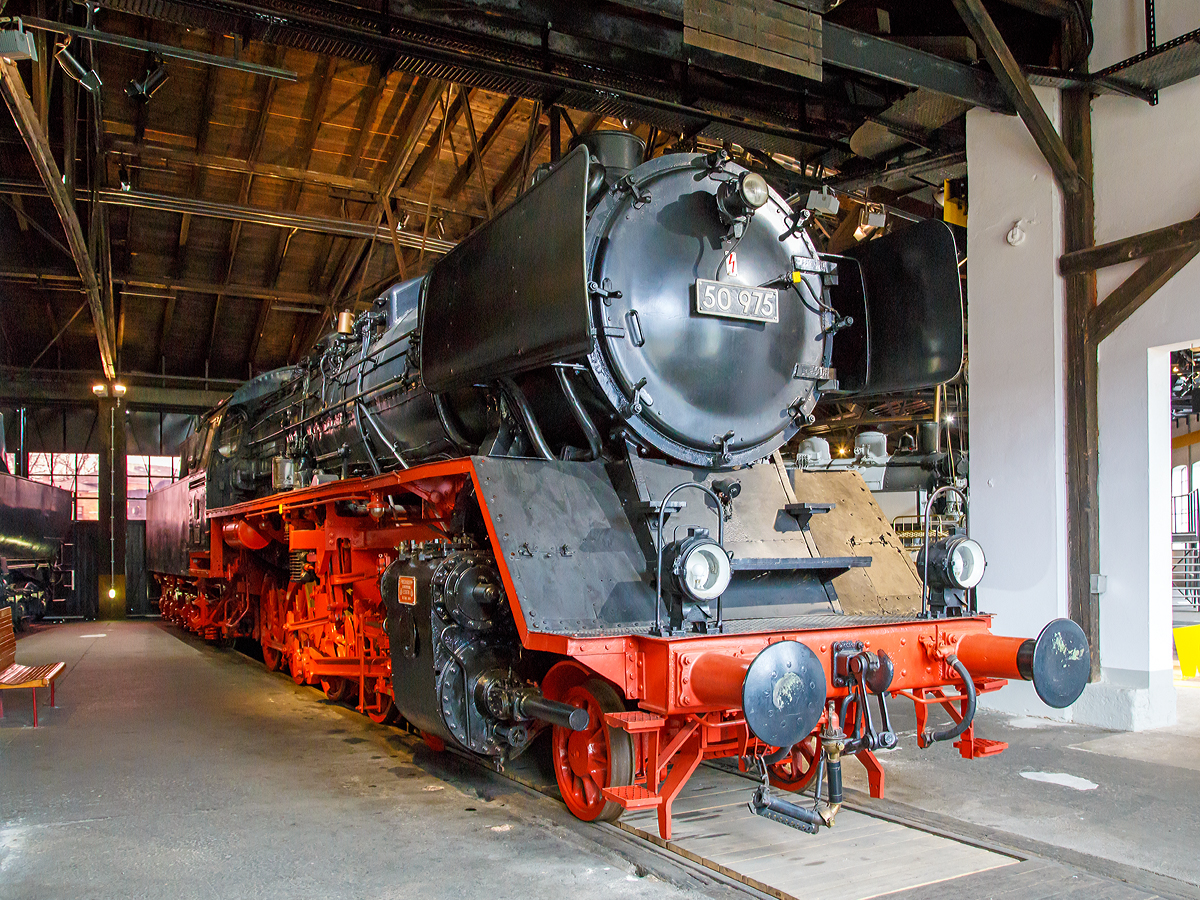 Die Güterzug-Dampflokomotive 50 975, ex DB 050 975-2, am 26.03.2016 im DDM - Deutsches Dampflokomotivmuseum in Neuenmarkt-Wirsberg.

Die Lok wurde 1941 von der Friedrich Krupp GmbH in Essen unter der Fabriknummer 2340 gebaut und als DRB 50 975 an die Deutsche Reichsbahn geliefert. Seit 15.Februar 1961 hat die Lok den Kessel der 50 2830, dieser wurde 1942 von der Krauss-Maffei AG (München-Allach) unter der Fabriknummer 16347 gebaut. Der Tender ist der originale von Krupp (Fabriknummer 2340). 

Als einzige 50er-Lok der Deutschen Bundesbahn erhielt sie für die Versuchseinsätze beim Bundesbahn-Zentralamt Minden eine Riggenbach-Gegendruckbremse, dort war sie auch vom 01.06.1951 bis zum 01.03.1963 stationiert.

Zum 15.02.1975 erfolgte die z-Stellung und am 16.05.1975 die Ausmusterung (Bw Weiden) bei der Deutschen Bundesbahn. Bis dahin hatte sie eine Laufleistung von 1,6 Mio. km. Im Jahr 1976 kam sie dann zum DDM.


Die Güterzuglokomotiven der Baureihe 50 zählen zu den bewährtesten Konstruktionen der Deutschen Reichsbahn. Am Ende der Dampflokzeit sind sie zur Universalgattung geworden, die Dank der niedrigen Achslast auch auf Nebenbahnen eingesetzt werden konnten. Bis 1943 wurden 3164 Maschinen der Baureihe 50 von nahezu allen europäischen Lokomotivfabriken gebaut.


Bei der DB wurden nach dem Zweiten Weltkrieg 2159 einsatzfähige Lokomotiven registriert, bei 735 Lokomotiven rüstete die DB den Tender mit einer Zugführerkabine aus. Eine kleinere Anzahl von Lokomotiven wurde mit einem Mischvorwärmer bestückt und insgesamt 31 Lokomotiven wurden mit Franco-Crosti-Anlagen ausgerüstet und anschließend als Reihe 50.40 geführt.


Technische Daten:
Gebaute Stückzahl: 3.164
Spurweite: 1.435 mm (Normalspur)
Bauart:  1'E h2
Gattung: G 56.15
Länge über Puffer.  22.940 mm
Höhe:  4.500 mm
Fester Radstand  3.300 mm
Gesamtradstand  9.200 mm
Dienstgewicht:  86,9 t (ohne Tender)
Achslast: 15,2 t
Höchstgeschwindigkeit  80 km/h (vorwärts und rückwärts)
Leistung: 1.625 PS
Treib- und Kuppelraddurchmesser: 1.400 mm
Laufraddurchmesser:  850 mm
Steuerungsart  Heusinger mit Hängeeisen
Zylinderanzahl:  2
Zylinderdurchmesser:  600 mm
Kolbenhub: 660 mm
Kesselüberdruck:  16 bar
Anzahl der Heizrohre  113
Anzahl der Rauchrohre  35
Heizrohrlänge  5.200 mm
Rostfläche:  3,89 m2
Überhitzerfläche:  68,94 m2
Verdampfungsheizfläche:  177,83 m2
Tender:	2´2´ T 26
Wasservorrat:	26 m³	
Brennstoffvorrat: 8 t (Kohle)
