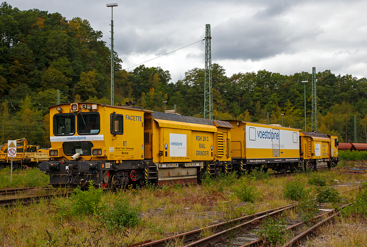 
Die Harsco Track Technologies Gleis- und Weichenschleifmaschine (engl. Rail Grinder) RGH 20 C „Facette“, Schweres Nebenfahrzeug Nr. 99 80 9127 001-2 D-VABWG, der voestalpine BWG GmbH aus Butzbach (Betreiber – EVU: Hessische Güterbahn GmbH) ist am 28.09.2020 in Betzdorf (Sieg) abgestellt.

Der Schienenschleifzug wurde 2010 von der Harsco Track Technologies (HTT) in den USA unter den Fabriknummern 153635 und 153636gebaut. Das Fahrzeug hat die EBA-Nummer EBA 03C18A003.

Der Schienenschleifzug ist dreiteilig, an beiden Enden befinden sie die selbstfahrende 4-achsige (2 Drehgestelle) 10-Steine-Schienenschleifmaschinen (RGH 10C2-38 bzw. RGH 10C2-39) und dazwischen ein antriebsloser zweiachsiger Mittelwagen. Die selbstfahrende 20-Steine-Schienenschleifmaschine dient zur Beseitigung von Fahrflächenfehlern, Schäden aus Rollkontaktermüdung und der kohlenstoffarmen Randschicht aus dem Walzprozess sowie zur Schienenkopfprofilierung. Der Einsatz erfolgt vorwiegend in Weichen, Kreuzungen und Bahnübergängen ohne Demontage von Ausrüstungsteilen.
Jeder Schleifkopf bestehend aus einem Hydromotor, einer Spindel-Lager-Einheit und einer Schleifscheibe ist unabhängig gelagert und wird einzeln gesteuert, so dass bei 1 Überfahrt 10 verschiedene Facetten geschliffen werden können. Die Winkelstellung, seitliche Position und Sollstellung werden komplett in Schleifabläufen programmiert. 
Der Schleifdruck jeder Scheibe ist einzeln regelbar. Der zulässige Winkelbereich beträgt 75˚ auf der Schieneninnenseite bis 45˚ auf der Schienenaußenseite, gemessen zur Senkrechten. Zur Kontrolle des Ergebnisses ist ein Schienenprofilmesssystem vorhanden.

An beiden Schleifwagen ist eine Staubabsaug und-sammeleinrichtung vorhanden, die Absaugung erfolgt jeweils durch einen Ventilator, der einen Luftstrom von ca. 8.000 m³/h erzeugt. Beide Schleifwagen verfügen zudem über eine integrierte Feuerlöschanlage.

Technische Daten:
Spurweite: 1.435 mm
Achsfolge: Bo’Bo’ + 2 + Bo’Bo’
Anzahl der Achsen: 10
Länge über Puffer: 41.738 mm (13,94 / 13,85 / 13,94 m)
Breite: 2.629 mm
Höhe über SOK: 3.928 mm
Gesamtgewicht: 124 t
max. Achslast: 15 t (Zul. Streckenklasse A und höher)
Höchstgeschwindigkeit (Eigen / Schlepp): 100 km/h
Kleister befahrbarer Gleisbogen: R 90 m
Zur Mitfahrt zugel. Personen: 5
Max. Anhängelast: 50 t

Schleifspezifische Kennwerte:
Aufstelllänge vor Schleifbeginn: 60 m
Geräuschentwicklung (25 m Abstand): 73 dbA
Schleifgeschwindigkeit: 3 bis 8 km/h
Schleifrichtungen: 2 
Drehzahl der Schleifmotoren: 5.500-6.000 min-1
Leistung der Schleifmotoren: 17 kW
Schleifscheiben: Topfscheibe (16 Stück) Ø 152 mm und Tellerscheibe (4 Stück) Ø 280 mm