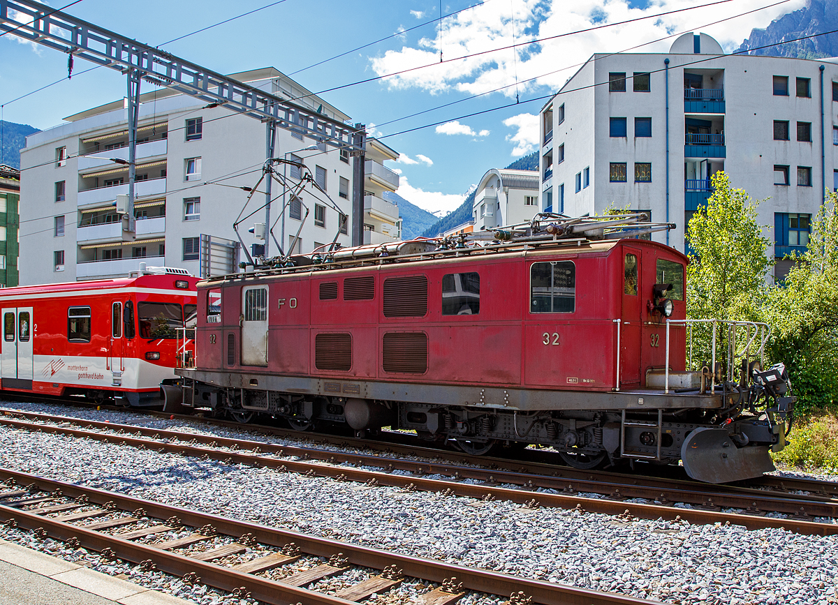 
Die HGe 4/4 I - 32 der Matterhorn-Gotthard-Bahn (MGB), ex FO 32, zieht am 20.06.2016 den Stadler Niederflurgelenksteuerwagen ABt 2134 (passent zu den Stadler KOMETen) in Brig vom Bahnhof zum Depot.

Die HGe 4/4 ist eine schmalspurige (1.000 mm) gemischte Zahnrad- und Adhäsions-Elektrolokomotive. Die für die ehemalige Furka-Oberalp-Bahn (FO) gebauten HGe 4/4I 31–37 wurden nach dem Vorbild der HGe 4/4I 16 der Visp-Zermatt-Bahn (VZ), jedoch aber mit stärkerer elektrischer Ausrüstung, gebaut.

Die Lokomotiven besitzen zwei zweiachsige Drehgestelle. Die Zug- und Stoßvorrichtungen – das heißt Puffer, Zughaken und Kupplungslasche – sind jeweils direkt mit dem Drehgestellrahmen verbunden. Im Gegensatz dazu werden diese Vorrichtungen heute bei Drehgestelllokomotiven in der Regel am Lokomotivkasten befestigt. Die bei der Beförderung von Zügen auftretenden Zug- und Druckspannungen wirken im Normalbetrieb daher zunächst direkt auf das in Fahrtrichtung hintere Drehgestell. Erst über eine zentrale kugelige Drehpfanne werden die Kräfte auf eine Brücke, die aus kräftigen Profilen zusammengenietet ist, und von dort auf das vordere Drehgestell übertragen. Auf dieser Brücke aufgebaut ist der sehr leicht konstruierte Lokomotivkasten.

Die FO-Loks haben einen Anschluss für die Speisung der 1941–1945 ebenfalls von SLM/MFO gelieferten elektrischen Schneeschleudern Xrot e 4931–4933.

Technische Daten:
Spurweite: 1.000 mm
Achsformel: Bo'Bo'
Hersteller: SLM Winterthur / Maschinenfabrik Oerlikon
Dienstgewicht: 47 t
Länge über Puffer: 14.120 mm
Höchstgeschwindigkeit : 55 km/h (Adhäsion)  / 30 km/h (Zahnrad)
Anzahl der Motoren: 4
Stundenleistung: 890 kW
Stromsystem: Einphasenwechselstrom 11 kV / 16,7 Hz,
Zahnstangensystem : Systems Abt (mit zwei Lamellen)