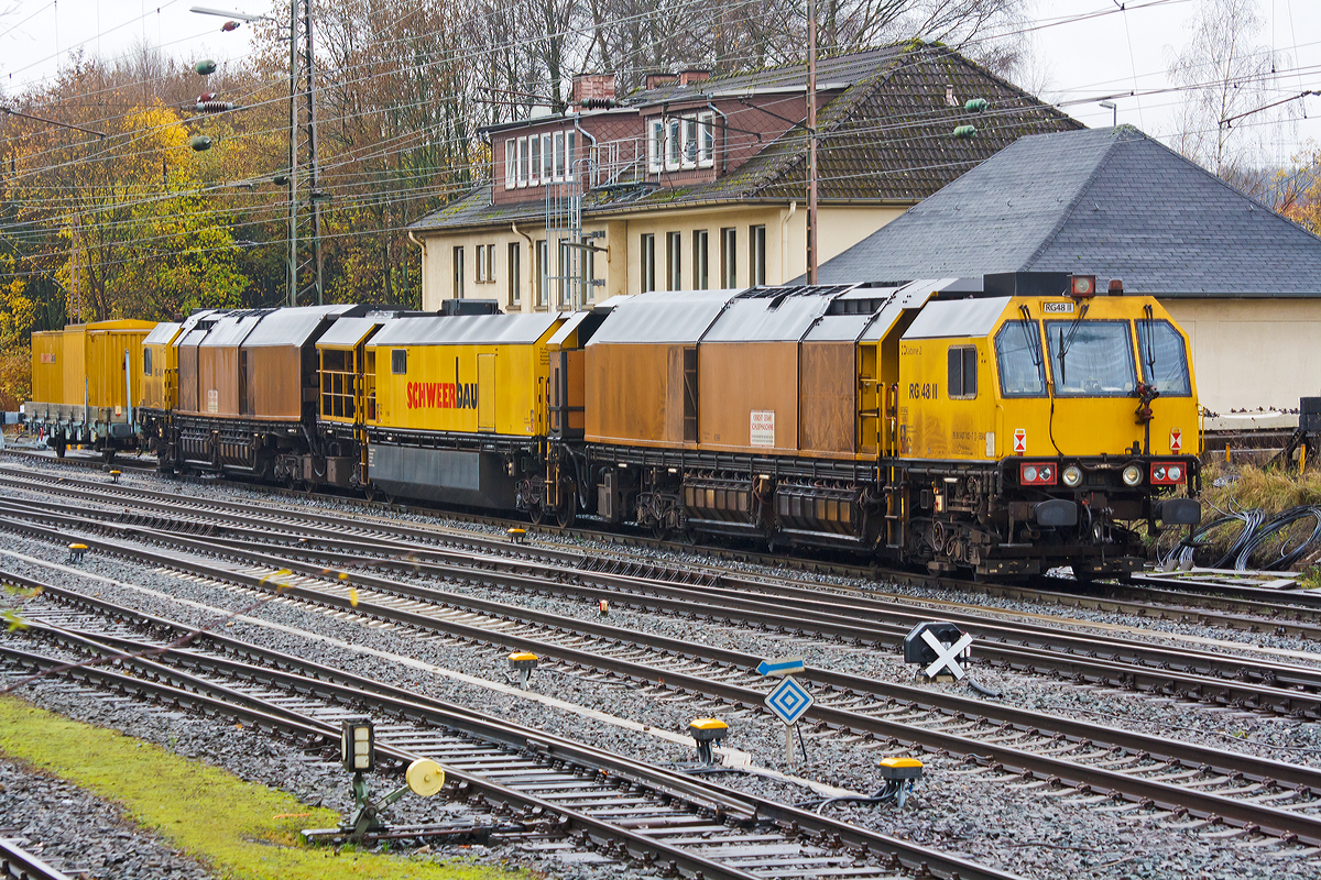 
Die LORAM Schienenschleifmaschine RG 48 II, Schweres Nebenfahrzeug Nr. 99 80 9427 002-7 D-SAUB, der Schweerbau abgestellt am 16.11.2014 in Kreuztal.

Die Schienenschleifmaschine RG 48 besteht aus drei Wagenteilen, zwei Schleifwagen (1+2) und eine Arbeitswagen dazwischen. Jeder Wagen hat zwei Drehgestelle mit zwei Achsen. Die Schleifwagen haben insgesamt 48 Schleifmodule (24 pro Wagen), die elektrisch verstellt werden können, der Anpressdruck geschieht hydraulisch. Die Schleifmotoren  haben eine Leistung von jeweils 22,4 kW. Unter dem Arbeitswagen befindet sich ein Wassertank, mit einem Fassungsvermögen von 18.927 Liter (5.000 Gallon), für Kühl- und Löschwasser. Die Maschinen kann in beide Richtungen arbeiten. Der kleinste bearbeitbare Bogenradius beträgt 180 m. Die Arbeitsgeschwindigkeit ist zwischen 2 und 15 km/h stufenlos einstellbar und abhängig vom Materialabtrag, vorzugweise wir zwischen 8 und 12 km/h gearbeitet. Bei einer Schleifgeschwindigkeit von 8 km/h können 0,25 mm Material angetragen werden. Für das Schleifen des gesamten Schienenkopfes beträgt die Stundenleistung zwischen 700 und 1400 m Gleis.

Hersteller dieser Maschine ist Loram Maintenance of Way, Inc. aus Minnesota (USA).

Technische Daten:
Spurweite: 1.435 mm
Anzahl der Achsen: 12 (in 6 Drehgestellen)
Länge über Puffer: 62.043 mm (3 x 20.810 mm)
Drehzapfenabstände: 13.110 mm
Achsabstände in den Drehgestellen: 1.800 mm
Raddurchmesser: 920 mm
Eigengewicht: 245.000 kg
Achslast: 21,5 t
Zul. Anhängelast: 40 t
Zur Mitfahrt zugel. Personen: 6
Höchstgeschwindigkeit: 100 km/h
Kleinster befahrbarer Gleisbogen: R 150 m
Zugelassen für Streckenklasse: D2 und höher


Die Schienen sind gehören zum wertvollsten Kapital der meisten Eisenbahnen. Die Schnittstelle von Rad und Schiene ist ein anspruchsvolles Thema, vor allem wegen der Kosten zu spät beseitigten Mängel. Typische Probleme auf allen angetroffen Eisenbahnen gehören Schälstellen, Abplatzungen, Seitenverschleiß, getaucht Schweißnähte, Riffen und Ermüdungen, sowie einzigartigen Herausforderungen der Lärmminderung und Fahrqualität.

Das Schienenschleifen gilt als die effektivste Wartung der Praxis, um die Auswirkungen von dem Verscheiß an der Schiene wiederherzustellen.
Zu der Investitionsrendite einer gut gewarteten (frühzeitig geschliffenen) Schiene gehören:
Ein längeres Schienen Leben;
Energie-  Kraftstoffersparnis;
Reduzierter Verschleiß an dem Rollmaterial;
Höhere Achslasten und Zuggeschwindigkeiten und
Verbesserte Fahreigenschaften und Komfort für die Passagiere.
