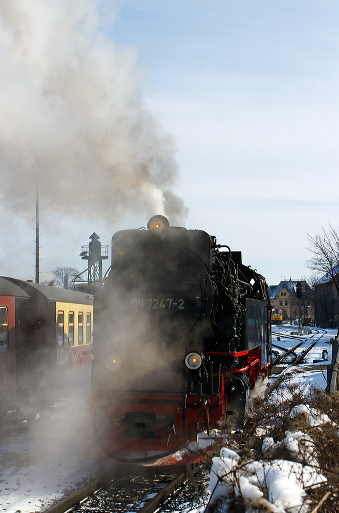 
Die Neubau-Dampflok der Harzer Schmalspurbahnen HSB 99 7247-2 (ex DR 099 157-0, 99 0247-9, 99 247) rangiert am 23.03.2013 in Wernigerode, um ihren Personenzug am Gleis an zu hängen. 

Die Meterspurige Dampflok wurde 1957 bei LKM (VEB Lokomotivbau Karl Marx Babelsberg unter der Fabriknummer 134028 gebaut und als DR 99 247 an die Deutsche Reichsbahn geliefert. Zum 01.07.1970 erfolgte die Umzeichnung in DR 99 7247-2, nachdem man sie 1980 auf Ölfeuerung umbaute wurde sie als DR 99 0247-7 bezeichnet. Da die Ölfeuerung nicht zum Vorteil der Maschinen war und Öl in der DDR knapp war wurde sie (wie alle Loks) 1983 wieder auf Kohlefeuerung zurück gebaut und nun wieder als DR 99 7242-2 bezeichnet. Ab dem 01.01.1992 wurden die Lok noch als DR 099 157-0 um bezeichnet, bis am 01.02.1993 in die HSB überging, welche dann wieder die alte DR-Bezeichnungen verwendete.
