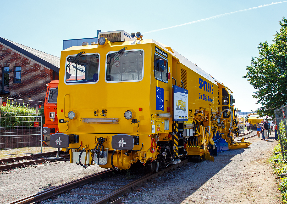 
Die neue Plasser & Theurer Schotterverteil- und Planiermaschine USP 4000 SWS, Schweres Nebenfahrzeug-Nr. D-SPAG 99 80 91 25 012-1, der SPITZKE SE, präsentiert auf der iaf 2017 in Münster (hier am 01.06.2017).

Die USP 4000 SWS wurde 2017 von Plasser & Theurer in Linz (A) unter der Maschinen Nr. 6723 gebaut.

Die Schotterverteil- und Planiermaschine USP 4000 SWS stellt das perfekte Schotterbett von Gleisen und Weichen in nur einem Arbeitsdurchgang her. Das „One-Pass-Verfahren“ soll die Verteilung und Planierung des Schotters in einem Arbeitsgang ermöglichen. Die neue Anordnung der Aggregate ermöglicht, dass der aufgekehrte Schotter direkt vor die Arbeitsorgane oder durch die vier Entladeöffnungen des Bodenförderbands an jeder gewünschten Stelle im Bereich der Stopfzonen ausgegeben werden kann.

In der „Technischen Spezifikation für die Interoperabilität zum Teilsystem Fahrzeuge – Lärm“ (TSI Noise 2015) wurden für neue Schienenfahrzeuge europaweit einheitliche Grenzwerte festgelegt. Die Schotterverteil- und Planiermaschine USP 4000 SWS gehört zu den ersten Maschinen, die diese Vorgaben erfüllt, und markiert deshalb einen neuen Standard. 

Bei der USP 4000 SWS sind alle Aggregate so angeordnet, dass technologisch richtiges Arbeiten möglich ist und die Verteilung und Planierung des Schotters in einem Arbeitsgang erfolgen kann. Durch das Bodenförderband und die Verteilschächte im vorderen Teil der Maschine kann sie auch für punktuelle Einschotterungen eingesetzt werden. 

Entscheidend bei allen Einsätzen ist das neue Design mit zwei Kabinen, das uneingeschränkte UIC-Sicht in beide Fahrtrichtungen gewährleistet. Bei Überstellfahrten lässt sich die USP 4000 SWS nun wie das Schotterbewirtschaftungssystem BDS vorwärts- und rückwärtsfahren. 

Besonderes Augenmerk wurde bei der Konstruktion auf den Schutz vor Lärm und Staub gelegt. So erhielt die Kehranlage für Gleise und Weichen eine spezielle Gummiauskleidung, die sowohl den Lärm als auch den Verschleiß reduziert. Das Schottersilo mit einem Fassungsvermögen von 5 m³ ist mit ROBALON-Kunststoffplatten ausgekleidet. Eine Staubniedernebelungsanlage reduziert die Staubemissionen im gesamten Arbeitsumfeld.
Bei leerem Silo erfüllt die Maschine auch die Anforderungen der Streckenklasse C2. Im Rahmen der iaf 2017 wurde diese neue USP 4000 SWS der Firma Spitzke übergeben, als topaktuelle Ergänzung für die leistungsfähige Instandhaltungsflotte.  

TECHNISCHE DATEN:
Spurweite: 1.435 mm
Achsanzahl: 4
Länge über Puffer: 19.140 mm
Drehzapfenabstand: 11.500 mm
Achsabstand im Drehgestell: 1.800 mm
Eigengewicht: 64 t
Motorleistung: 470 kW
Max. Geschwindigkeit geschleppt:  90 km/h
Max. Geschwindigkeit Eigenantrieb: 100 km/h
Min. Kurvenradius: 120 m

Leistungsparameter:
Arbeitsleistung bei Durcharbeitung des Gleises: max. 1.800 m/h
Arbeitsleistung bei Umbau des Gleises: max. 1.400 m/h
Arbeitsradius: ≥ 150 m
Arbeiten in Überhöhung: max. 180 mm
