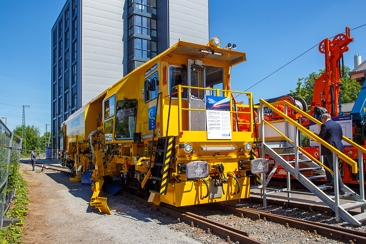 
Die neue Plasser & Theurer Schotterverteil- und Planiermaschine USP 4000 SWS, Schweres Nebenfahrzeug-Nr. D-SPAG 99 80 91 25 012-1, der SPITZKE SE, präsentiert auf der iaf 2017 in Münster (hier am 01.06.2017).

Die USP 4000 SWS wurde 2017 von Plasser & Theurer in Linz (A) unter der Maschinen Nr. 6723 gebaut.

Die Schotterverteil- und Planiermaschine USP 4000 SWS stellt das perfekte Schotterbett von Gleisen und Weichen in nur einem Arbeitsdurchgang her. Das „One-Pass-Verfahren“ soll die Verteilung und Planierung des Schotters in einem Arbeitsgang ermöglichen. Die neue Anordnung der Aggregate ermöglicht, dass der aufgekehrte Schotter direkt vor die Arbeitsorgane oder durch die vier Entladeöffnungen des Bodenförderbands an jeder gewünschten Stelle im Bereich der Stopfzonen ausgegeben werden kann.

In der „Technischen Spezifikation für die Interoperabilität zum Teilsystem Fahrzeuge – Lärm“ (TSI Noise 2015) wurden für neue Schienenfahrzeuge europaweit einheitliche Grenzwerte festgelegt. Die Schotterverteil- und Planiermaschine USP 4000 SWS gehört zu den ersten Maschinen, die diese Vorgaben erfüllt, und markiert deshalb einen neuen Standard. 

Bei der USP 4000 SWS sind alle Aggregate so angeordnet, dass technologisch richtiges Arbeiten möglich ist und die Verteilung und Planierung des Schotters in einem Arbeitsgang erfolgen kann. Durch das Bodenförderband und die Verteilschächte im vorderen Teil der Maschine kann sie auch für punktuelle Einschotterungen eingesetzt werden. 

Entscheidend bei allen Einsätzen ist das neue Design mit zwei Kabinen, das uneingeschränkte UIC-Sicht in beide Fahrtrichtungen gewährleistet. Bei Überstellfahrten lässt sich die USP 4000 SWS nun wie das Schotterbewirtschaftungssystem BDS vorwärts- und rückwärtsfahren. 

Besonderes Augenmerk wurde bei der Konstruktion auf den Schutz vor Lärm und Staub gelegt. So erhielt die Kehranlage für Gleise und Weichen eine spezielle Gummiauskleidung, die sowohl den Lärm als auch den Verschleiß reduziert. Das Schottersilo mit einem Fassungsvermögen von 5 m³ ist mit ROBALON-Kunststoffplatten ausgekleidet. Eine Staubniedernebelungsanlage reduziert die Staubemissionen im gesamten Arbeitsumfeld.
Bei leerem Silo erfüllt die Maschine auch die Anforderungen der Streckenklasse C2. Im Rahmen der iaf 2017 wurde diese neue USP 4000 SWS der Firma Spitzke übergeben, als topaktuelle Ergänzung für die leistungsfähige Instandhaltungsflotte.  

TECHNISCHE DATEN:
Spurweite: 1.435 mm
Achsanzahl: 4
Länge über Puffer: 19.140 mm
Drehzapfenabstand: 11.500 mm
Achsabstand im Drehgestell: 1.800 mm
Eigengewicht: 64 t
Motorleistung: 470 kW
Max. Geschwindigkeit geschleppt:  90 km/h
Max. Geschwindigkeit Eigenantrieb: 100 km/h
Min. Kurvenradius: 120 m

Leistungsparameter:
Arbeitsleistung bei Durcharbeitung des Gleises: max. 1.800 m/h
Arbeitsleistung bei Umbau des Gleises: max. 1.400 m/h
Arbeitsradius: ≥ 150 m
Arbeiten in Überhöhung: max. 180 mm