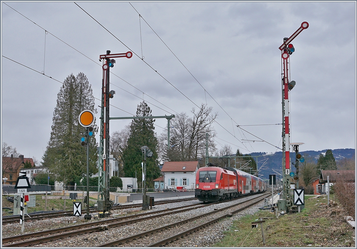 Die ÖBB 1116 098 nähert sich von Bregenz kommend dem Einfahrvorsignal von Lindau Hbf, während die Form Haupt- und Vorsignale von Lindau Reutin von der Gegenseite her das Bild zieren.
14. März 2019
