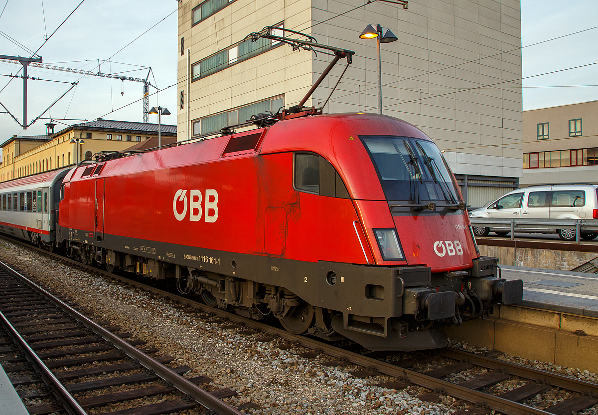 
Die ÖBB 1116 161 (A-ÖBB 91 81 1116 161-1) als Schublok des EC 112 „Blauer Enzian“ am 08.02.2020 beim Halt im Hauptbahnhof Augsburg.

Die ÖBB Taurus II eine elektrische Universallokomotive vom Typ Siemens ES64U2 wurde 2003 von Siemens in München unter der Fabriknummer 20882 und als 1116 161-9 an die ÖBB geliefert.

Die ES 64 U2 wurde ursprünglich als Universallok für die Österreichischen Bundesbahnen (ÖBB) entwickelt und wird dort als Baureihe 1016 (reine 15-kV-Version) und 1116 (2-System-Version mit 15 kV und 25 kV für internationalen Verkehr) geführt. Die Zweisystembauart für 15 kV- und 25 kV-Bahnstromsysteme ist traktions- und sicherungstechnisch für Deutschland, Österreich und Ungarn ausgerüstet und zugelassen, seit Mai 2002 ist zudem ihr Einsatz teilweise in der Schweiz erlaubt. Durch die vorhandene Technik ist sie ebenso für die Wechselstromstrecken in Tschechien und der Slowakei geeignet. Die Maschinen der Serie ES 64 U2 sind wendezugfähig ausgeführt und ab Werk mit zwei Einholm-Stromabnehmern ausgerüstet. Ausnahme sind die Railjet-Loks 1116.201 bis 1116.223, welche mit den in die Schweiz verbundenen Fahrten, einen dritten (schmaler) Stromabnehmer haben. Der Antrieb der Lok erfolgt über einen speziell für sie entwickelten Hohlwellen-Antrieb mit Bremswelle (HAB).

Die Lok der Reihe 1016 und 1116 sind auch oft hörbar zuerkennen: Beim Aufschalten aus dem Leerlauf ist ein Geräusch zu vernehmen, das an das Durchspielen einer Tonleiter auf einem Tenorsaxophon erinnert. Es entsteht in den Drehstrommotoren durch die Ansteuerung der Stromrichter. Das hörbare Geräusch ist dabei die doppelte Taktfrequenz der Pulswechselrichter, welche stufenweise angehoben wird.

Die Frequenz ändert sich dabei in Ganz- und Halbtonschritten über zwei Oktaven von d bis d  im Tonvorrat der Stammtöne.

TECHNISCHE DATEN:
Spurweite: 1.435 mm (Normalspur)
Achsformel: Bo’Bo’
Länge über Puffer: 19.280 mm
Höhe: 4.375 mm
Breite: 3.000 mm
Drehzapfenabstand: 9.900 mm
Achsabstand in Drehgestell: 3.000 mm
Kleinster bef. Halbmesser: 100 m (bei 10 km/h) /120 m (bei 30 km/h)
Dienstgewicht: 88 t
Max. Achslast: 22 t
Höchstgeschwindigkeit: 230 km/h
Dauerleistung: 6.400 kW
Max. Leistung (Booster für 5 min): 7.000 kW (nur bei 85–200 km/h nützlich)
Anfahrzugkraft: 300 kN
Dauerzugkraft: 250 kN (bis 92 km/h)
Raddurchmesser: 1.150 mm (neu) / 1.070 mm (abgenutzt)
Motorentyp: 1 TB 2824-0GC02
Stromsystem: 15 kV, 16,7 Hz und 25 kV, 50 Hz
Anzahl der Fahrmotoren: 4
Antrieb: GTO Stromrichter und Hohlwellen-Drehstrom Fahrmotoren
Dynamisches Bremssystem: Elektrodynamische Hochleistungs-Rückspeisebremse
Nenn- / Höchstleistung der dynamischen Bremse: 6.400 kW / 7.000 kW (mit Booster)
Max. Bremskraft der dynamischen Bremse: 240 kN
