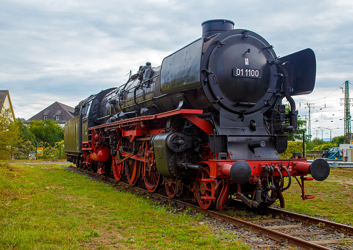 
Die ölgefeuerte Dreizylinder-Schnellzug-Dampflokomotive 01 1100, ex DB 012 100-4, steht am 04.09.2020 im DB Museum Koblenz-Lützel. Die Lok wurde 1940 von der BMAG (Berliner Maschinenbau-Actien-Gesellschaft vormals L. Schwartzkopff), in Berlin unter der Fabriknummer 11356 gebaut und wurde an die Deutsche Reichsbahn geliefert. Am 31. Mai 1975 wurde die Lok bei der DB letztmalig planmäßig eingesetzt, zum 01.06.1975 erfolgte die z-Stellung und am 26.06.1975 die ausmusterung im Bw Rheine. 

Die Dampflokomotiven der Baureihe 01.10 waren von der Deutschen Reichsbahn im Rahmen des Einheitsdampflokomotiv-Programms beschaffte Schnellzuglokomotiven und eine Weiterentwicklung der Baureihe 01.

Die Deutsche Reichsbahn benötigte für ihr Netz schnellfahrender D- und FD-Züge leistungsstarke Dampflokomotiven mit einer Höchstgeschwindigkeit von 150 km/h. Es sollten Züge von 550 Tonnen in der Ebene mit 120 km/h sowie Züge von 425 Tonnen auf einer Steigung von 4 ‰ noch mit 100 km/h befördert werden.

Die bereits vorhandenen Lokomotiven der Baureihen 01 und 03 waren zwar nur für 120 bzw. 130 km/h zugelassen, konstruktiv jedoch bereits auf eine Höchstgeschwindigkeit von 140 km/h ausgelegt. Die starken Zuckbewegungen durch das Zweizylindertriebwerk dieser Baureihen ließen die höhere Geschwindigkeit jedoch nicht zu. Auch im Hinblick auf bessere Anfahreigenschaften entschied man sich zur Beschaffung von Maschinen mit laufruhigeren Dreizylindertriebwerken, dies ebenfalls wieder mit einfacher Dampfdehnung.

Zur Verringerung des Fahrwiderstandes wurden die Fahrzeuge mit einer bis 400 mm über Schienenoberkante heruntergezogenen Stromlinienverkleidung ausgerüstet. Durch diese konnte, wie Versuche mit der Baureihe 03 zeigten, die Zugleistung bei Geschwindigkeiten von 140 km/h um 48 ‰ gesteigert werden. Diese Mehrleistung bei höheren Geschwindigkeiten wurde bei der Baureihe 01.10 allerdings teilweise wieder durch die schlechtere Dampfversorgung des Dreizylindertriebwerkes im Vergleich zum Zweizylindertriebwerk aufgezehrt.

Bei einem berechneten Bedarf von 400 Lokomotiven wurden 1939 zunächst 204 Stück bei allen großen Lokomotivfabriken in Deutschland bestellt. Kriegsbedingt wurden jedoch nur 55 Lokomotiven ausgeliefert. Alle Maschinen stammten von Schwartzkopff (BMAG). 1944 wurden alle Lokomotiven wegen der Kriegsereignisse nach Westdeutschland verlegt. Nach dem Zweiten Weltkrieg befanden sich die Maschinen in einem desolaten Zustand. Vielfach fehlten Teile der Stromlinienverkleidung und die Kessel aus der als Kesselbaustoff nicht alterungsbeständigen Stahlsorte St 47 K zeigten erste Ermüdungserscheinungen. Am 20. Juni 1945 wurde die Ausmusterung über die gesamte Baureihe verfügt. Die Lokomotiven waren bis zu diesem Zeitpunkt jeweils weniger als 500.000 Kilometer gefahren. Aufgrund des herrschenden Lokomotivmangels nach dem Krieg griff man im Weiteren doch wieder auf die Baureihe zurück, einige Maschinen mit kleineren Schäden wurden vorläufig instandgesetzt.

Der Großteil der Lokomotiven blieb jedoch bis 1949 abgestellt. Im selben Jahr entschloss man sich, sämtliche Lokomotiven, bis auf eine (01 1067), die endgültig ausgemustert blieb, einer Aufarbeitung zu unterziehen. Im Rahmen dieser Aufarbeitung wurde die Stromlinienverkleidung von Lokomotive und Schlepptender vollständig entfernt und es wurden Windleitbleche der sogenannten Bauart Witte montiert. 

Ungelöst blieb das Problem der Kessel aus St 47 K, bei dem Schäden durch Ermüdungen und als Folge von Schweißungen auftraten. Da man im Betrieb auf die Maschinen nun nicht mehr verzichten konnte, entschloss man sich 1953, neue geschweißte Hochleistungskessel mit Verbrennungskammer in Auftrag zu geben. Diese wurden zwischen 1953 und 1956 bei Henschel in Kassel beschafft und im AW Braunschweig zusammen mit einer Mischvorwärmeranlage nach Bauart Heinl eingebaut. Die Verdampfungsleistung der über einen größeren Anteil an Strahlungsheizfläche verfügenden Neubaukessel war trotz geringerer Rost- und Gesamt-Verdampfungsheizfläche um rund 10 % höher als bei den Altbaukesseln. Bei den Maschinen mit Ölfeuerung waren Dampfverbräuche bis hinunter zu 5,8 kg/PSih möglich. 

1956 erhielt die 01 1100 zusammen mit dem neuen Kessel versuchsweise eine Ölhauptfeuerung. Mit dieser konnte die Leistung der Lok nennenswert erhöht werden, außerdem konnte die Ölfeuerung elastischer geregelt und damit den Betriebsverhältnissen besser angepasst werden. Die Maschinen waren daher wirtschaftlicher als kohlegefeuerte Dampfloks. Die Arbeit des Heizers wurde durch das Wegfallen des Kohleschaufelns erleichtert, da die Brennstoffzufuhr nun durch einen Schieber reguliert wurde. Der Heizer konnte überdies den Lokführer nun besser bei der Streckenbeobachtung unterstützen.

Verfeuert wurde das seinerzeit als Abfallprodukt vorhandene Schweröl (Bunker-C). Aufgrund der positiven Erfahrungen entschloss man sich 1957, weitere 33 Lokomotiven dieser Baureihe auf Ölfeuerung umzubauen. 1968 erhielten die kohlegefeuerten Lokomotiven bei der Umstellung auf das EDV-konforme Nummernsystem die Baureihenbezeichnung 011, die ölgefeuerten die 012.

Am 31. Mai 1975 wurden die letzten Maschinen der Baureihe, die teilweise Monatsleistungen von über 25.000 Kilometern und Gesamtkilometerleistungen von deutlich über 3,5 Millionen Kilometern erbracht haben, vom Bw Rheine letztmals planmäßig eingesetzt und anschließend unter Anteilnahme von Eisenbahnfreunden ausgemustert.

TECHNISCHE DATEN: 
Ausmusterung:  1975
Bauart:  2’C1’ h3
Gattung:  S 36.20 (Schweiz A 3/6)
Spurweite:  1.435 mm (Normalspur)
Länge über Puffer:  23.130 mm
Höhe:  4.550 mm
Leergewicht (ohne Tender):  101 t
Gewicht Lok und Tender: 177 t
Radsatzfahrmasse:  20 t
Höchstgeschwindigkeit:  vorwärts 150 km/h, rückwärts 50 km/h
Indizierte Leistung:  1.817 kW (ca. 2.470 PS)
Treibraddurchmesser:  2.000 mm
Laufraddurchmesser vorn: 1.000 mm 
Laufraddurchmesser hinten:  1.250 mm
Steuerungsart:  Heusingersteuerung mit Hängeeisen
Zylinderanzahl: 3
Zylinderdurchmesser:  500 mm 
Kolbenhub:  660 mm
Kesselüberdruck:  16 bar
Anzahl der Heizrohre:  119 
Anzahl der Rauchrohre: 44
Heizrohrlänge: 5.000 mm
Rostfläche:  3,96  m² 
Strahlungsheizfläche: 22 m²
Überhitzerfläche:  96,15 m² 
Verdampfungsheizfläche: 206,51 m² 
Tender:  2’3 T 38
Wasservorrat:  38,0 m³
Brennstoffvorrat:  13,5 t Schweröl
Zugheizung: Dampf