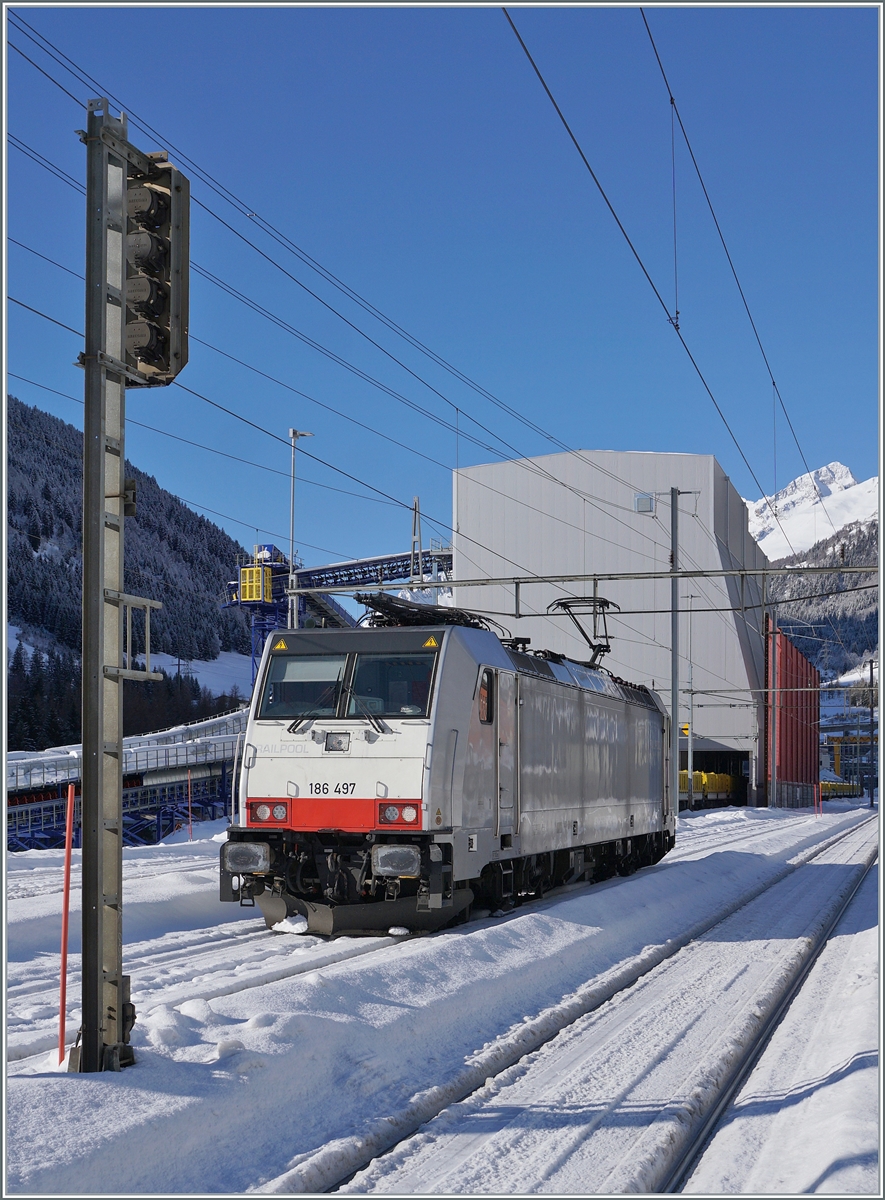 Die Railpool 186 497 hat in Airolo ihren aus Sggrrs S 204 Wagen bestehenden Ganz-G�terzug unter die Beladungseinrichtung rangiert und f�hrt nun auf ein Wartegleis, bis der Zug beladen ist. Das Verschieben des Zuges besorgt eine Am 841. 

21. Jan. 2025