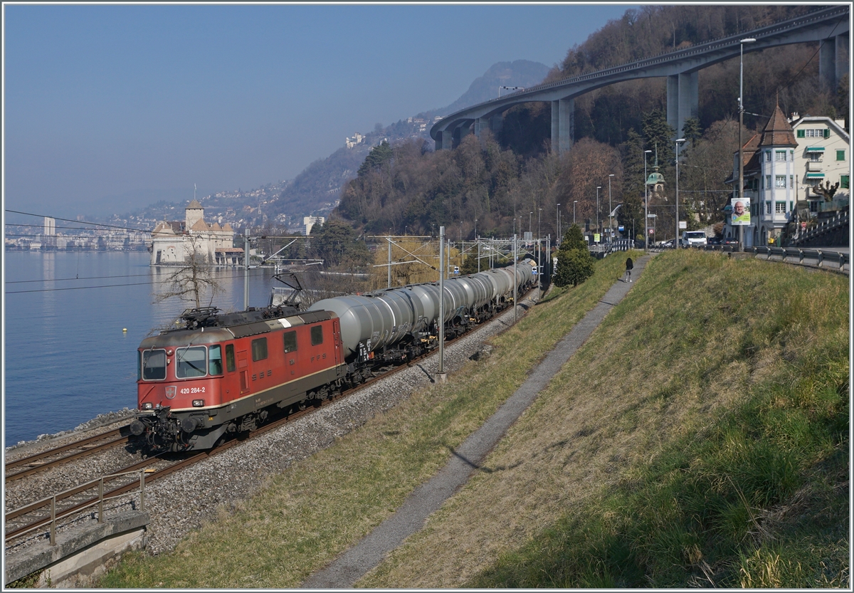 Die SBB Re 4/4 II 11284 (Re 420 284-5) ist mit einem Kesselwagenblockzug beim Château de Chillon auf dem Weg in Richtung Aigle. 

8. März 2022 