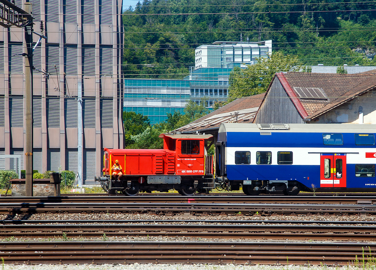 Die SBB Tmf 232 302-0 (Tmf 98 85 5 232 302-0 CH-SBB) rangiert am 11.07.2022 einige Personenwagen beim Bahnhof Olten (Aufnahme aus einem Zug durch die Scheibe).

Die dieselhydraulische Rangierlok (Rangiertraktor) wurde 1975 von Schweizerische Lokomotiv- und Maschinenfabrik (SLM) in Winterthur unter der Fabriknummer 5064 gebaut und als Tm IV 9665 an die Schweizerische Bundesbahnen (SBB / CFF / FFS) geliefert. Im Jahr 1999 ging sie an die SBB Infrastruktur. 

Im Jahr 2013 hat die SBB Infrastruktur das Retrofit von 15 Tm IV Rangierloks in Auftrag gegeben.  So wurde auch diese Lok 2013 einer umfassenden Modernisierung (Retrofit), im SBB Industriewerk Biel, unterzogen. So geh�ren unter anderem ein verbrauchsarmer Caterpillar-Dieselmotor, ein Partikelfilter, eine zus�tzliche Ladeluftk�hlanlage, eine neue Fahrzeugsteuerung, eine neue Sicherheitssteuerung, Zugsicherungen, die Funkfernsteuerung und schlie�lich die �nderung der Bordspannung von 36 auf 24 Volt zum Umfang dieser Modernisierung. Durch die M�glichkeit der Mehrfachtraktion sowie der Funkfernsteuerung ist ein effizienter und wirtschaftlicher Betrieb m�glich. So werden die bereits �ber 40-j�hrigen Tm IV als Tmf 232.3 viele weitere Jahre Dienst auf dem Schweizer Schienennetz leisten k�nnen. Die Tmf 232.3 verf�gen zus�tzlich, gegen�ber den Tm 232 �ber eine Vielfachsteuerung, GSM-R Funk und Baufunk.

Fahrzeugrahmen
Eine sehr robuste geschwei�te Rahmenkonstruktion bildet das Grundger�st des Fahrzeuges, auf dem sich einerseits die F�hrerkabine, welche fest mit dem Rahmen verschwei�t ist, sowie alle notwendigen Unterlagen und Konsolen f�r die Aufnahme der einzelnen Komponenten.
Die Unterseite besteht aus zwei massiven L�ngstr�gern, in welchen
die zwei Achshalter eingelassen sind und die Bremskomponenten
aufnehmen. Diese sehr robuste Konstruktion hat eine gute Krafteinleitung zur Folge.

An beiden Enden des Triebfahrzeuges befindet sich je eine Stirn-
platte, worauf die Puffer angeschraubt sind. Die Zugvorrichtung ist
mit einem Federelement ebenfalls an der Stirnplatte befestigt.

Zug- und Stossvorrichtung
Die Zugvorrichtung besteht aus dem Zughaken und einer Schraubenkupplung, bei der Tmf 232 ist zus�tzlich ist eine Rollwagenkupplung angebracht. Die Sto�vorrichtung besteht aus Puffern ohne Deformationselemente, welche direkt auf der Stirnplatte angeschraubt sind.

Fahrwerk
Das Fahrwerk besteht aus zwei Rads�tzen mit Scheibenr�dern. Auf
der Au�enseite der Achswellen sind die Achslagergeh�use mit
Zylinderrollenlager angebracht. Die Achslagergeh�use sind mittels Manganplatten im Achshalter gef�hrt. Der Fahrzeugrahmen st�tzt sich �ber vier Blattfederpakete ohne Lastausgleich auf die Achslagergeh�use ab.

Kraft�bertragung
Das Drehmoment wird vom Motor mittels einer Kardanwelle auf das Voith-Turbowendegetriebe, dann auf das Verteilgetriebe und schlie�lich �ber Kardanwellen auf die Achsen �bertragen.

Turbowendegetriebe
Das Voith-Turbogetriebe ist ein vollautomatisch arbeitendes, hydrodynamisches Str�mungsgetriebe f�r die Kraft�bertragung zwischen Dieselmotor und Triebachsen. Es besteht im Wesentlichen aus zwei hydrodynamischen Wandlern, bei welchen die Kraft�bertragung durch die Massenkr�fte einer Betriebsfl�ssigkeit (Mineral�l) erfolgt.

Die zwei hydrodynamischen Wandler und bestehen aus je
einem Pumpenrad, Turbinenrad und feststehendem Leitrad. Im
Pumpenrad wird die vom Dieselmotor abgegebene mechanische Energie in Str�mungsenergie umgewandelt. Im nachfolgenden Turbinenrad wird durch Verz�gerung und Umlenkung der
Fl�ssigkeitsma�e wieder mechanische Energie zur�ckgewonnen.
Das im Turbinenrad entstehende Drehmoment ist abh�ngig vom
Grad der Umlenkung der Betriebsfl�ssigkeit. Die Umlenkung und
damit das Turbinendrehmoment ist bei festgehaltener Turbine am
gr��ten und f�llt mit zunehmender Turbinendrehzahl ab. Das
Leitrad als dritter Hauptbestandteil eines hydrodynamischen
Wandlers hat die Aufgabe, die Zulaufrichtung zum Pumpenrad
unabh�ngig von der Abstr�mrichtung des Turbinenrades konstant
zu halten, so dass die Leistungsaufnahme des Pumpenrades von
der Turbinendrehzahl nicht beeinflusst wird. Das Leitrad erm�glicht
auf diese Weise eine Drehmomentwandlung und nimmt das Differenzmoment zwischen Pumpenrad und Turbinenrad auf.

Motor
Der Dieselmotor ist ein wassergek�hlter, verbrauchsarmer Caterpillar- 6 Zylinder-Viertakt-Dieselmotor mit Ladeluftk�hlung (Industriemotor), welcher bei 1.600 U/min eine Leistung von 280 kW abgibt. Er erf�llt die Euro-III<A Norm bez�glich den Abgaswerten. 


Technische Daten des Dieselmotores:
Fabrikat: Caterpillar vom Typ C13 Acert
K�hlung: Wasser
Arbeitsverfahren: Viertakt
Verbrennungsverfahren :Direkteinspritzung
Aufladung:  Abgas-Turboaufladung mit Luft-Luft-Ladeluftk�hlung
Zylinderzahl / Bauform:  6-Zylinder Reihen-Motor
Verdichtungsverh�ltnis 17,3:1
Kolbendurchmesser / -hub: 130 mm / 157 mm
Hubraum: 12,5 Liter
Motorgewicht: 1.350 kg
Leerlaufdrehzahl:  600 U/min
Maximale Drehzahl: 1.600 U/min
Maximales Drehmoment: 1.897 Nm bei 1.400 U/min
Abgasanlage Partikelfilte

Der Dieselmotor ist �ber elastische Gummilager auf dem Fahrzeugrahmen montiert. Die beiden Brennstofftanks mit total ca. 850
Liter Inhalt sind im Untergestell montiert. Die Abgasanlage inkl. Partikelfilter und Kompensatoren wird durch
den Vorbau und die Kabinenstirnwand gef�hrt

Abgasanlage
Die Triebfahrzeuge sind mit einem Partikelfilter ausger�stet, der
anstelle eines Schalld�mpfers in die Abgasleitung eingebaut ist. Der
Filter enth�lt eine Filterzelle aus Siliziumkarbid-Waben und ist f�r die
Reinigung der motorischen Abgase aus Diesel-Verbrennungsmotoren ausgelegt. Alle dem Abgasstrom ausgesetzten Teile sind in
Edelstahl ausgef�hrt. Damit werden auch bei hohen Temperaturen
Korrosionssch�den verhindert.

Prinzip des Partikelfilters
Das Abgas str�mt von der Rohgasseite in die Filterzelle aus Siliziumkarbid, lagert die Partikelfracht an der Zelle ab und durchstr�mt
die Zellwand zur Reingasseite. Der Filter darf bei Abgastemperaturen bis zu 600�C eingesetzt werden. Der Betrieb des Ru�partikelfilters l�uft komplett selbstst�ndig ab. Die Filtermodule verf�gen �ber eine katalytische Beschichtung, welche die Abbrandtemperatur je nach Ru�fracht der aufgefangenen Ru�partikel auf unter 300�C bringt

Bremsen
Das Triebfahrzeug verf�gt �ber die folgenden Bremssysteme:
• eine direkt wirkende, elektropneumatische Rangierbremse
• eine indirekt auf die Anh�ngelast wirkende Anh�ngerbremse
• eine elektropneumatisch gesteuerte Festhaltebremse
• eine elektropneumatisch gesteuerte Schleuderbremse
• eine Nachbremse
• eine Handbremse

Die Bremsen werden elektropneumatisch gesteuert. Je Fahrzeugseite ist ein Bremszylinder mit dazugeh�rigem Gleitschutzventil und Bremsgest�nge angeordnet. Jedes Rad wird beidseitig durch je einen Bremsklotz gebremst. Die Bremsklotzabn�tzung wird durch
einen Bremsgest�ngesteller (Stopex) je Bremszylinder ausgeglichen.

Rangierbremse
Die Rangierbremse wirkt nur auf das Triebfahrzeug und ist als
direkte Bremse ausgef�hrt. Die direkte Bremse wird mit dem Fahr-
/ Bremshebel bet�tigt. Ein Druckregler begrenzt den Druck auf h�chstens 3,5 bar. Die Rangierbremse kann nicht ausgeschaltet werden

TECHNISCHE DATEN:
Spurweite: 1.435 mm
Achsfolge: B (2/2)
L�nge �ber Puffer: 7.670 mm
Achsstand: 3.570 mm
Treibraddurchmesser: 950 mm (neu) / 870 mm (abgenutzt)
Breite: 3.150 mm
H�he: 4.200 mm
Gewicht: 30 t
Leistung Dieselmotor:  280 kW
Max. Drehmoment Dieselmotor: 1.870 Nm
Maximale Anfahrzugkraft am Rad: 90 kN
Dauerzugkraft am Rad: 60 kN
H�chstgeschwindigkeit: 30 km/h (Rangiergang) / 60 km/h (Streckengang), geschleppt 80 km/h
Kleinster befahrbarer Kurvenradius: 35 m
Brennstoffvorrat: 850 l
Bremsgewicht. 30 t
Handbremsgewicht: 10 t
