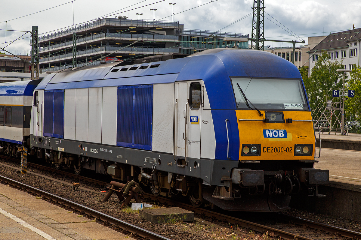 Die Siemens ER20 - DE2000-02 (92 80 1223 054-8 D-NOB) der Nord-Ostsee-Bahn GmbH steht am 16.06.2015 im Bahnhof Hamburg-Altona mit dem NOB Zug nach Westerland auf Sylt zur Abfahrt bereit.

Die ER 20 wurde 2005 von Siemens 21180 gebaut. Siemens Eurorunner ist eine dieselelektrische Lokomotive der mittleren Leistungsklasse, ein MTU 16 V 4000 R41 16-Zylinder Common Rai Dieselmotor mit einer Leistung von 2.000 kW (2.719 PS) treibt einen angeflanschtem Drehstrom-Asynchrongenerator an, der erzeugt dabei den Strom, mit dem die vier Motoren (einer für jede Achse) angetrieben werden. Bei erhöhtem Leistungsbedarf wie zum Beispiel beim Anfahren oder auf kurzen Steigungsabschnitten kann die Zugsammelschiene (für die Energieversorgung der Wagen) abgeschaltet werden, sodass die gesamte elektrische Leistung für die Fahrmotoren genutzt werden kann.

TECHNISCHE DATEN:
Achsformel:  Bo’Bo’
Spurweite:  1435 mm (Normalspur)
Länge über Puffer:  19.275 mm
Breite:  2.870 mm
Drehzapfenabstand:  10.362 mm
Achsabstand im Drehgestell:  2.700 mm
Kleinster bef. Halbmesser:  100 m
Dienstmasse:  80 t
Höchstgeschwindigkeit:  140 km/h
Installierte Leistung:  2.000 kW
Motorentyp:  Common Rail System
Motorbauart:  MTU 16 V 4000 R41
Nenndrehzahl:  600 - 1.800/Minute
Leistungsübertragung:  dieselelektrisch
Tankinhalt:  2800 l