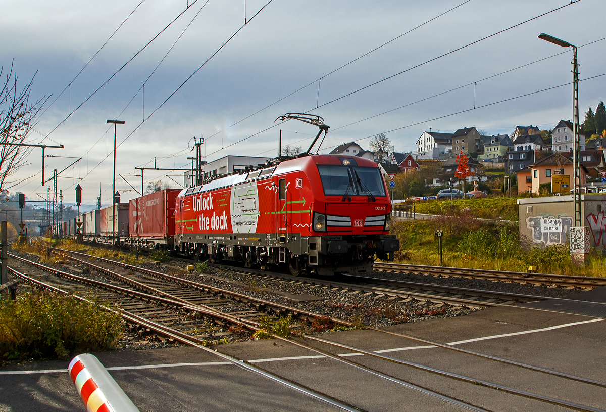Die Siemens Vectron MS 193 342-3 „Unlock the Dock“ (91 80 6193 343-3 D-DB) der DB Cargo AG fährt am 10.11.2021 mit einem „HUPAC-Zug“ (KLV-Zug) durch Niederschelden in Richtung Siegen.

Die Vectron MS wurde 2018 von Siemens in München unter der Fabriknummer 22422 gebaut und an die DB Cargo geliefert. Diese Vectron Lokomotive ist als MS – Lokomotive (Multisystem-Variante) mit 6.400 kW konzipiert und zugelassen für Deutschland, Österreich, Schweiz, Italien, Belgien und Niederlande, sie hat eine Höchstgeschwindigkeit von 200 km/h. So ist es möglich ohne Lokwechsel vom Mittelmeer die Nordseehäfen Rotterdam oder Hamburg an zu fahren.

Die Vectron MS hat folgende Leistungen:
Unter 15kV, 16,7Hz und 25kV, 50Hz Wechselstrom mit 6.400kW;
unter 3kV Gleichstrom mit 6.000kW sowie
unter 1,5kV Gleichstrom 3.500kW

Auf dem Dach der Lok befinden sich vier Einholmstromabnehmer
Position A Pantograf für AC 1.450 mm breit (für Schweiz)
Position B Pantograf für DC 1.450 mm breit (für Italien)
Position C Pantograf für DC 1.950 mm breit (für Niederlande)
Position D Pantograf für AC 1.950 mm breit (für Deutschland, Österreich), Position D ist hier im Bild vorne.
