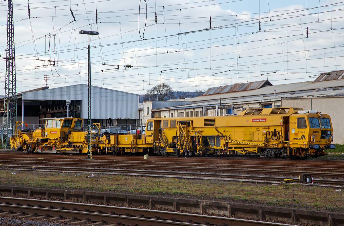 Die USM 741 eine Matisa Universal-Stopfmaschine B 66 U – D der DB Bahnbau Gruppe (Schweres Nebenfahrzeug Nr. 97 43 38 001 17-1), ex DB Netz AG, und die SSP 911 eine Deutsche Plasser Schnellschotterplaniermaschine SSP 110 SW (Schweres Nebenfahrzeug Nr. 97 16 40 065 18-3) der DB Bahnbau Gruppe, sind am 09.04.2016 beim Bahnhof Neuwied abgestellt.

Die Stopfmaschine wurde 1996 von Matisa (CH) unter der Fabriknummer 663 gebaut. Sie hat die EBA-Nummer EBA 95 Y 01 J 001.

Die B 66 U – D ist eine Hochleistungs-Universal-Stopfmaschine  mit  Einschwellen-Stopfeinheit f�r alle Weichentypen und die Strecke. Diese Maschine hat  Stopfwerkzeuge,  die  unabh�ngig  voneinander  in   drei Achsen bewegt werden k�nnen. Der abgehende Strang kann bis zu einem Abstand von 2.800 mm zur Gleisachse gestopft werden. Jede Stopfeinheit kann l�ngs 560 mm verfahren werden. Zus�tzlich zur  kombinierten Zange mit Haken und Rollen hat die B 66 U zwei teleskopisch ausfahrbare synchrone 3-Strang-Hebevorrichtungen. Mit  diesen Werkzeugen k�nnen schwerste Weichen mit Betonschwellen bearbeitet werden, insbesondere auf Hochgeschwindigkeitsstrecken.   Die Maschine kann auch Gelenkweichen und Strecken mit Y-Schwellen bearbeiten.

Technische Daten der Stopfmaschine:
Spurweite: 1.435 mm 
Achsfolge: Bo´2´(ohne Anh�nger)    
L�nge �ber Puffer : 30.180 mm  
Drehzapfenabstand: 14.000 mm
Eigengewicht: 89,3 t      
Nutzlast:  5 t      
Zul. Anh�ngelast: 40 t      
Zur Mitfahrt zugel.: 5 Personen      
Hg: 90 km/h

Noch einige Daten der  B 66 U aus dem Prospekt der Fa. Matisa:
 
Achsabstand der Drehgestelle: 1.800 mm
Raddurchmesser: 840 mm
Min. Kurvenradius im Arbeitsbetrieb: 150 m
Min. Kurvenradius im Fahrbetrieb: 100 m
Leistung des Dieselmotors:  563 kW 
Hebekraft:  2x 125 kN
Richtkraft:  150 kN
Max. Hebeweg:  150 mm
Seitlicher Verschiebebereich: +/- 200 mm
Seitliche Ausschwenkung des Stopfpickel in Bezug auf die Gleisachse: 2800 mm
L�ngsverschiebung der 4 Stopfeinheiten: 560 mm
Hebekraft f�r den Abzweigenden Strang: 120 kN
Max. Versatz in Bezug auf die Gleisachse: 3600 mm
Leistung auf der Strecke, 1x Stopfen: 650 – 680 m/h
Bearbeiten einer einfachen Weiche: 20 – 25 min
