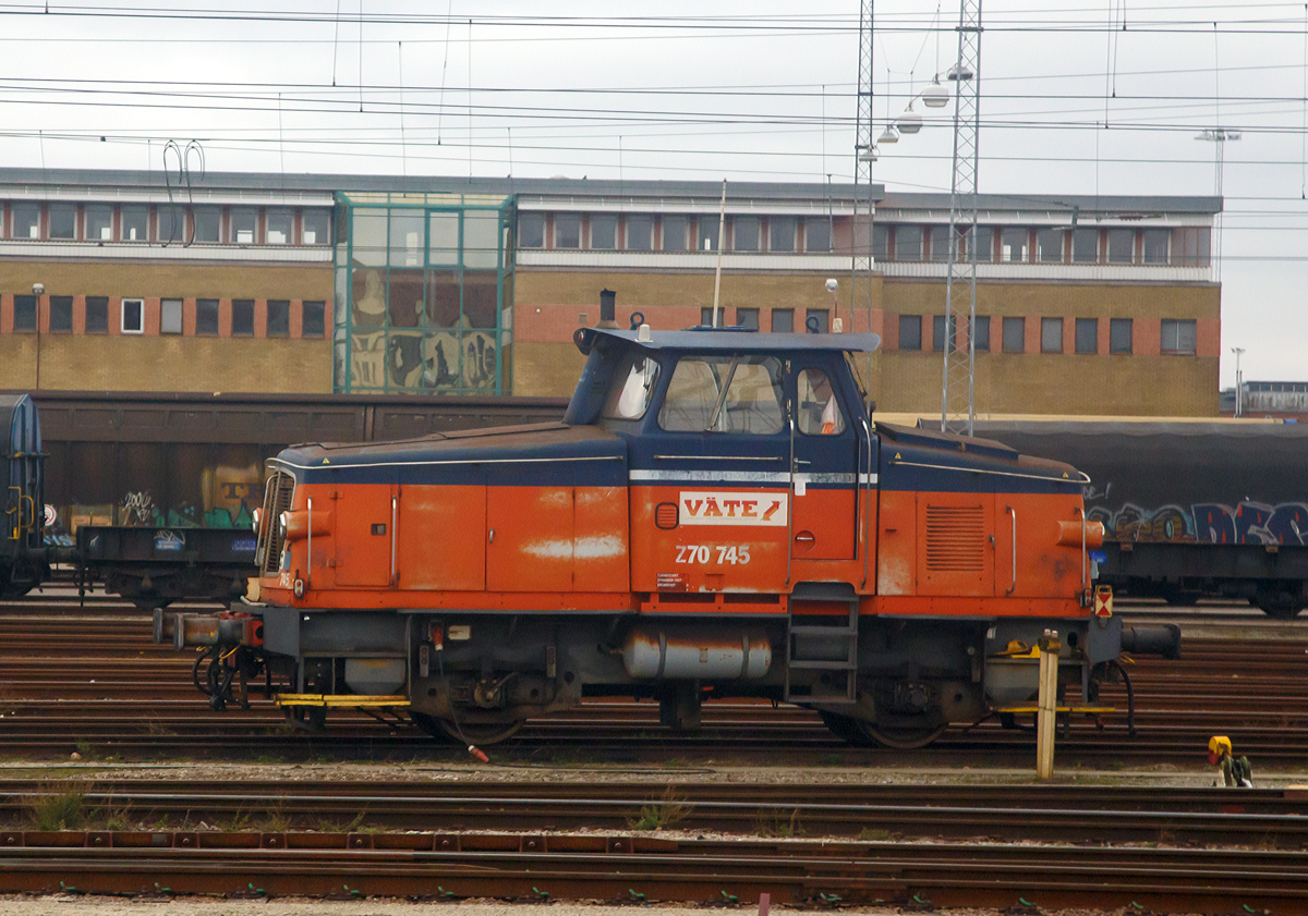 Die Väte Z70 745, ex GC Z70 745, ex SJ Z65 589, stand am 22.03.2019 im Rangierbahnhof Malmö und wartet auf ihren nächsten Einsatz. (Fotografiert aus dem Zug).

Die Lok wurde 1967 als Z65 589 von Kalmar Verkstad AB unter der Fabriknummer 344 gebaut und an die SJ (Statens Järnvägar, der ehemaligen schwedischen Staatsbahnen) geliefert. In den frühen 1990er Jahren beschlossen die SJ, eine Reihe Z65 zu modernisieren. So wurde 1992 die Z65 589 von Kalmar Verkstad AB zur Z70 745  modernisiert.

Die Baureihe Z70 sind eine Serie von schwedischen dieselhydraulischen Kleindiesellokomotiven, die aus modernisierten Lokomotiven der Baureihe Z65 hervorgingen. Die Lokomotiven wurden mit neuen Scania DSI-1447 Motoren (für die bislang vorhandenen Rolls-Royce-Motoren) und Fernsteuerung ausgerüstet. Um den größeren Motor unterzubringen, musste das Lokgehäuse erhöht werden. Daran können die umgebauten Lokomotiven sicher erkannt werden, zudem erhielten sie neue Seriennummern.

TECHNISCHE DATEN:
Anzahl: 50 (Umbau aus Z65)
Spurweite:  1.435 mm (Normalspur)
Achsformel: B
Länge über Kupplung: 9.360 mm
Dienstgewicht: 34 t
Höchstgeschwindigkeit: 70 km/h
Leistung: 333 kW (446 PS)
Anfahrzugkraft: 102 kN
Treibraddurchmesser:  985 mm
Motorentyp: Scania DSI-1447
Leistungsübertragung: Hydraulisch