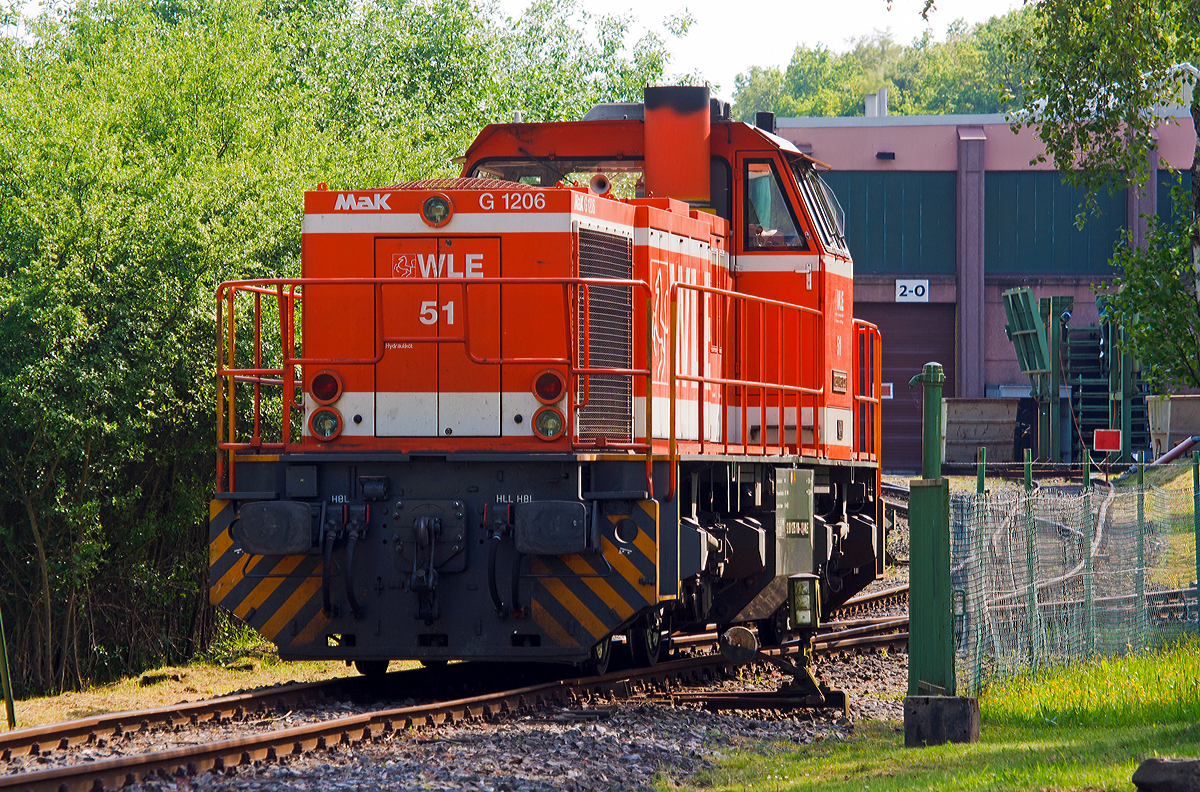 
Die WLE 51  Kreis Warendorf  (Westfälische Landes-Eisenbahn) eine MaK G 1206 steht am 20.05.2014 am dem Werksanschluß der Salzgitter Mannesmann Precision GmbH in Burbach-Holzhausen. 

Die Lok wurde 2002 bei Vossloh unter Fabriknummer 1001150 gebaut. Die komplette NVR-Nummer ist 92 80 1275 106-3 D-WLE, die EBA-Nummer EBA 02L22K 001.

Die Lokomotive MaK G 1206 ist eine dieselhydraulische Lokomotive, die von der Maschinenbau Kiel (MaK), ehemals DWK - Deutsche Werke Kiel, entwickelt wurde. MaK wurde 1998 von Vossloh gekauft und firmiert seither als Vossloh Locomotives. 

Technische Daten der WLE 51
Spurweite: 1.435 mm
Achsfolge	: B´B´
Länge über Puffer: 14.700 mm
Drehzapfenabstand: 7.200 mm
Drehgestellachsabstand: 2.400 mm
größte Breite: 3.080 mm
Höhe über Schienenoberkante: 4.220 mm
Raddurchmesser neu: 1.000 mm
kleinster befahrbarer Gleisbogen:	60 m
Dienstgewicht: 87,3 t
Kraftstoffvorrat: 3.500 l
	
Motor: 
Caterpillar 12 Zylinder 4-Takt Dieselmotor mit Abgasturbolader und Ladeluftkühlung vom Typ 3512B DI TA mit einer Leistung von 1.500 kW bei1.800 U/min
	
Strömungsgetriebe: Voith L5r4zU2
Höchstgeschwindigkeit	100 km/h
max. Schleppgeschwindigkeit : 80 km/h
kleinste Dauerfahrgeschwindigkeit: 10 km/h

Die MaK G 1206 ist im schweren Rangier- und Streckendienst einsetzbar. Sie wurde 1997 zum ersten Mal gebaut und ist nach Deutschland, Österreich, der Schweiz, Luxemburg, Italien, Spanien, den Niederlanden und nach Frankreich verkauft worden. Allein 23 Lokomotiven fahren als BB 61000 bei der SNCF, davon sechs mit MTU-Motor (Die G 1206 gibt es wahlweise mit Caterpillar- oder MTU-Motor).

Eine Weiterentwicklung der MAK 1206 ist die Vossloh G 1700 BB. In erster Linie wurde dabei der Rahmen so geändert, dass die Vossloh Standarddrehgestelle verwendet werden konnten. Motorisiert wurden die Loks mit dem MTU 12V 4000 R20 mit einer unveränderten Leistung von 1500 kW.

Bei der G 1700-2 BB dagegen handelt es sich um eine komplette Neuentwicklung. Die G 1206-2 ist hingegen eine für den Rangierdienst modifizierte Version der ursprünglichen G 1206. Sie ist mit Caterpillar-Motoren mit lediglich 920 kW und entsprechend kleineren Voith-Getrieben ausgestattet. Ihre Höchstgeschwindigkeit ist auf 50 km/h reduziert worden.
